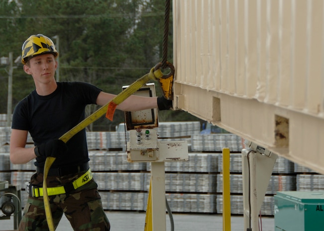 Airman 1st Class Zachary Folk assists in raising a container express to put it on a 436L pallet. Airman Folk is a logistics specialist with the 437th Aerial Port Squadron. (U.S. Air Force photo/Airman 1st Class Katie Gieratz)
