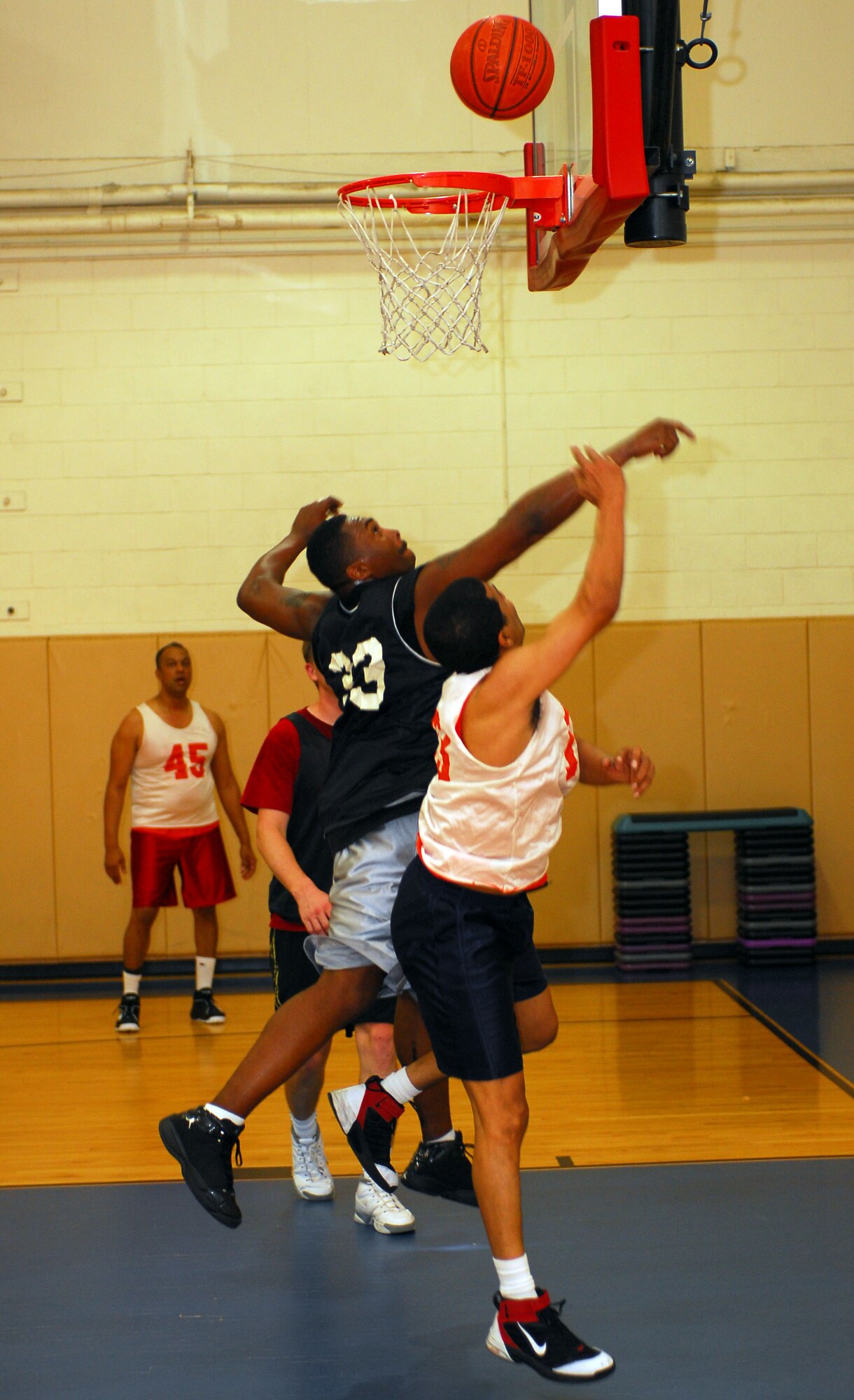 An Airman from the 1st Special Operations Medical Group (black jersey) and an Airman from the 1st Special Operations Communications Squadron (white jersey) jump up for a rebound during the over-30 basketball tournament March 17 in the Commando Fitness Center gym. The 1st SOMDG won the game 62-49, while the Air Force Special Operations Command team won the tournament. (U.S. Air Force photo/Airman 1st Class Jason Epley)
