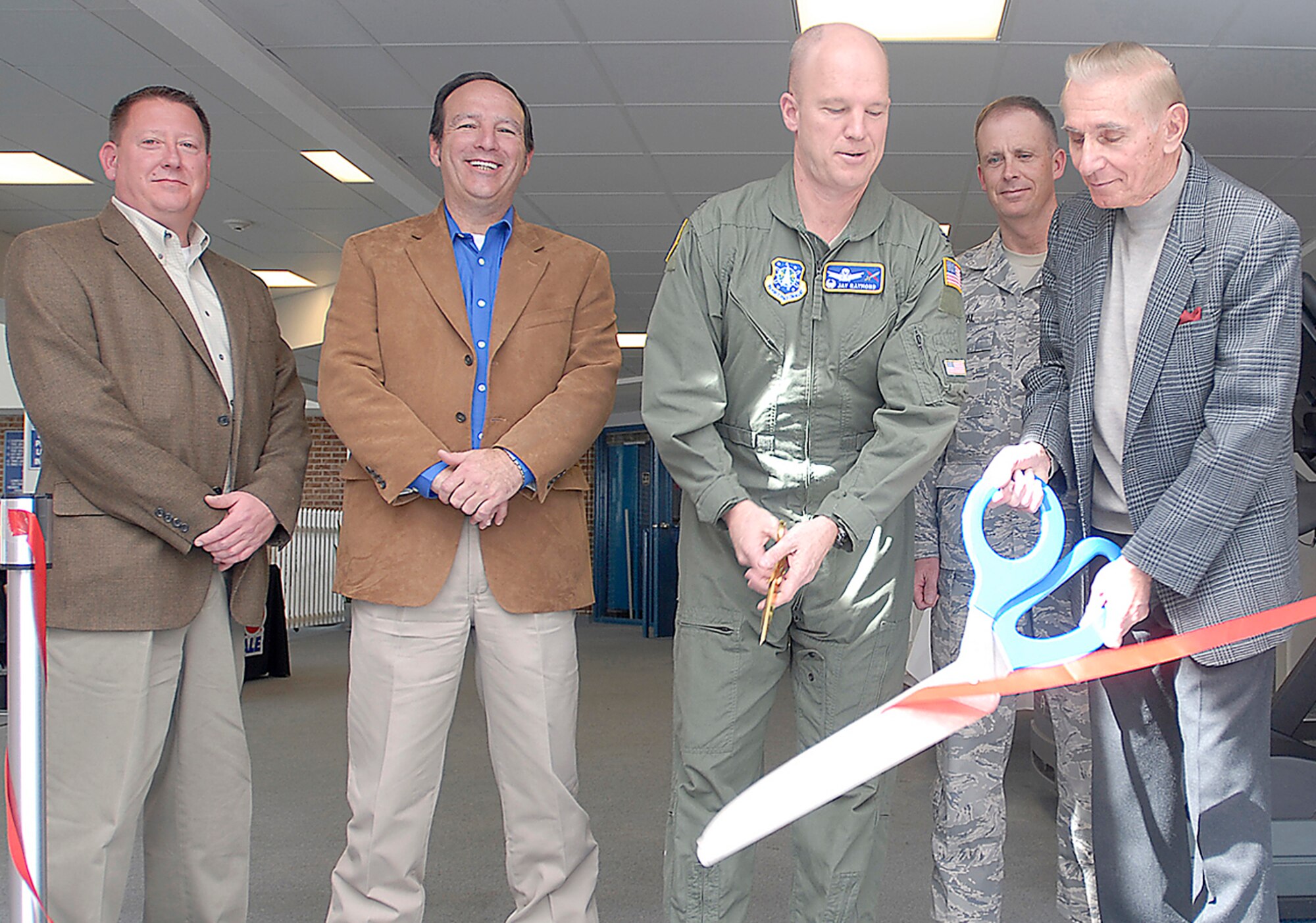 Col. Jay Raymond, 21st Space Wing commander (center), together with retired Air Force Gen. Don Kutyna, cut the ribbon to the grand re-opening of the Peterson Aquatics Center March 14. Following $2.8 million in upgrades, the pool is now covered by a new, durable roof structure, a new hot tub, slip-proof flooring and a new, $85,000 pool liner. (U.S. Air Force photo/Dennis Howk)