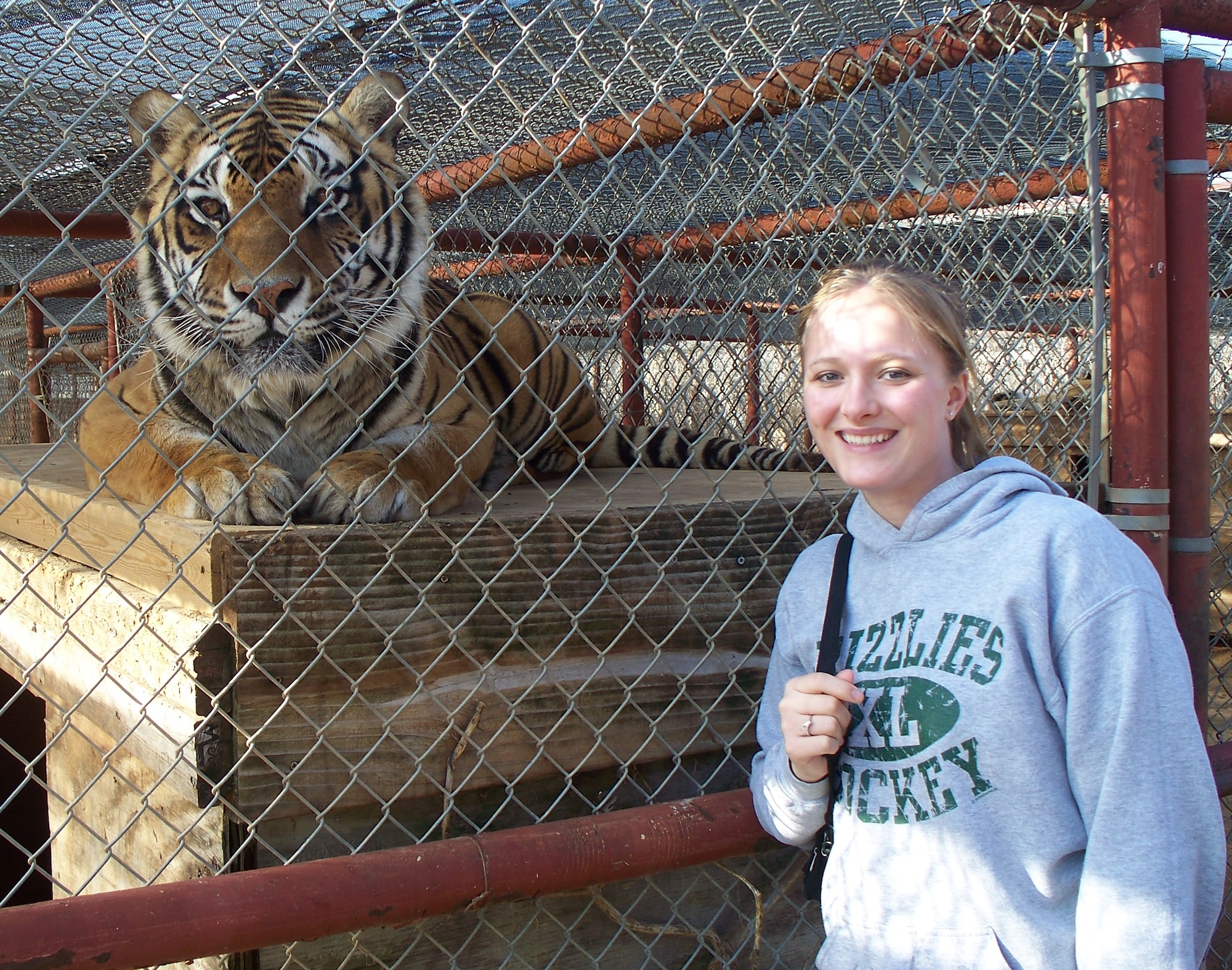Airman 1st Class Desiree Straughn of the 80th Operations Support Squadron takes time to pose with a big cat March 14 during the squadron's recent community service project. Twenty-five 80th OSS personnel volunteered time to help the Center for Animal Research and Education, near Bridgeport, Texas, clean up and repair a few areas of the Big Cat Habitat. (Courtesy photo)