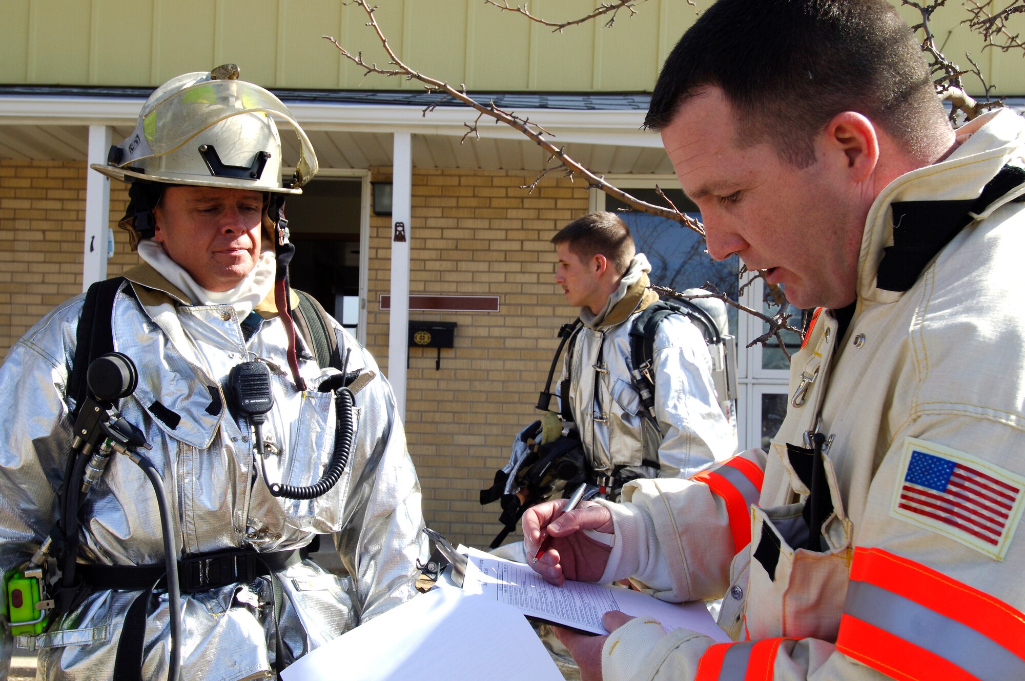 MINOT AIR FORCE BASE, N.D. -- (from left) The base deputy fire marshall, Chief Master Sgt. Robert Ward, looks on as Tech. Sgt. Kenneth Kline, assistant chief of operations at the base fire department, checks off safety procedures during a controlled house burn here March 17. (U.S. Air Force photo by Airman 1st Class Kelly Timney)