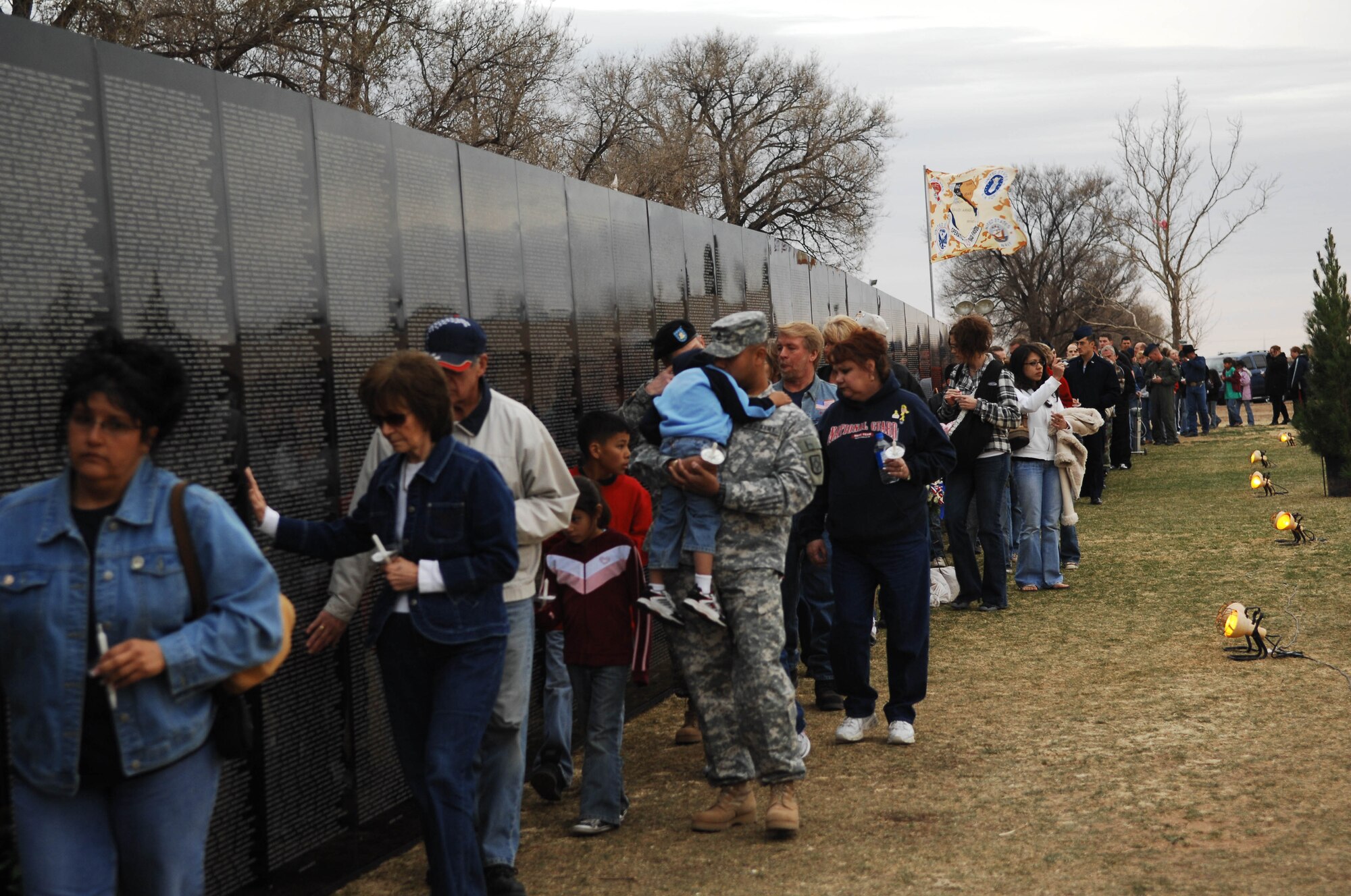 CANNON AIR FORCE BASE, N.M. - A line of military servicemembers and civilians walk along the Traveling Wall, an 80 percent replica of the Vietnam Memorial. The wall is one exhibit of the American Veterans Traveling Tribute, which stopped in nearby Clovis, N.M., March 13 - 19. (U.S. Air Force photo by Airman 1st Class Liliana Moreno)