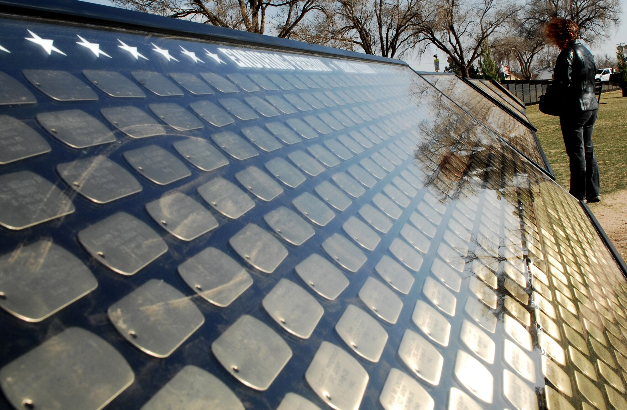 CANNON AIR FORCE BASE, N.M. - A woman looks at the Cost of Freedom Memorial, which consists of gold dog tags listing those who gave their lives since Vietnam and includes present day Operations Enduring and Iraqi Freedom. The memorial is one exhibit of the American Veterans Traveling Tribute, which stopped in nearby Clovis, N.M. March 13 - 19. (U.S. Air Force photo by Airman 1st Class Liliana Moreno)