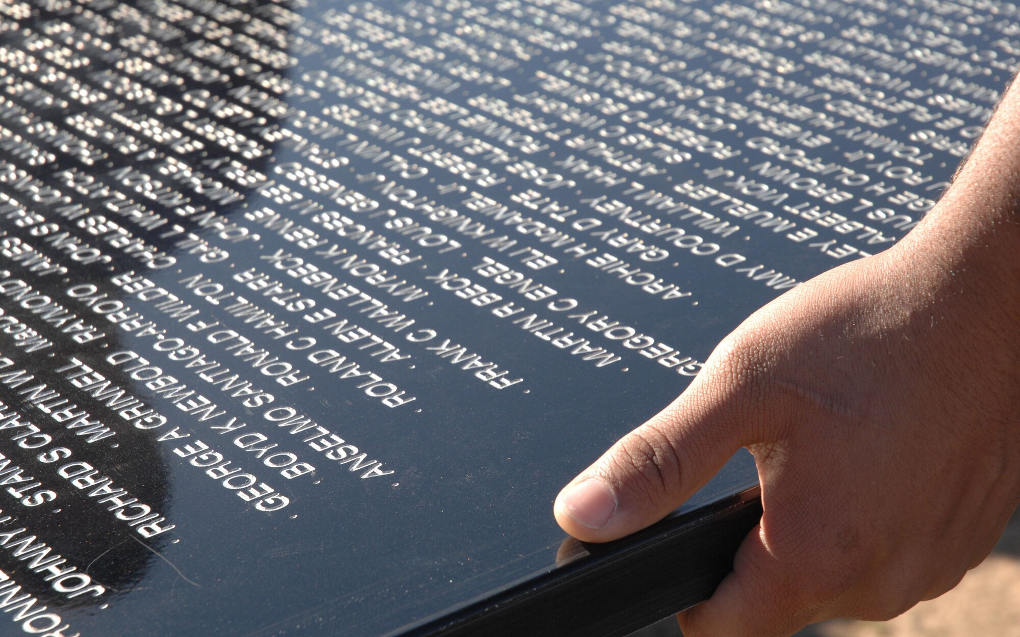CANNON AIR FORCE BASE, N.M. - The hands of a volunteer carry a piece of the Traveling Wall, an 80 percent replica of the Vietnam Memorial, during initial construction. The wall is one exhibit of the American Veterans Traveling Tribute, which stopped in nearby Clovis, N.M., March 13 - 19. (U.S. Air Force photo by Airman 1st Class Evelyn Chavez)