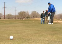 CANNON AIR FORCE BASE N.M. - Daniel Kizer eagle putts a golf ball into the hole at Whispering Winds Golf Course.  Mr. Kizer was on the second place team.  (U.S. Air Force photo by Airman 1st Class James R. Bell)