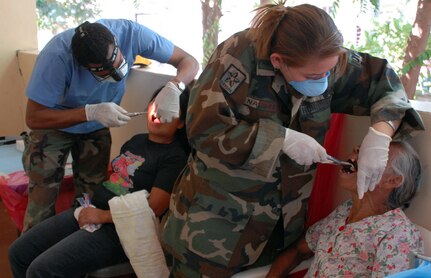 Air Force Dr. (Lt. Col.) Ray Williams (left) and Dr. Patricia Navarro, Honduran Army dentist, remove teeth from patients during the Morolica MEDRETE March. 10. A majority of the dental care provided was the extraction of decayed teeth, often the result of neglect combined with poor diets. (U.S. Air Force photo by Tech. Sgt. William Farrow)