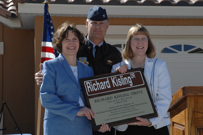 NELLIS AIR FORCE BASE, Nev. -- Col. Michael Bartley, 99th Air Base Wing commander, is flanked by Kathy Durant, left, and Karen Apple during the dedication ceremony naming a street in The Landings at Nellis housing area for their father, Chief Master Sgt. of the Air Force Richard D. Kisling.  Chief Kisling and his family were the first residents of the previous housing area on the site, Manch Manor. (U.S. Air Force photo by Senior Airman Nadine Barclay)