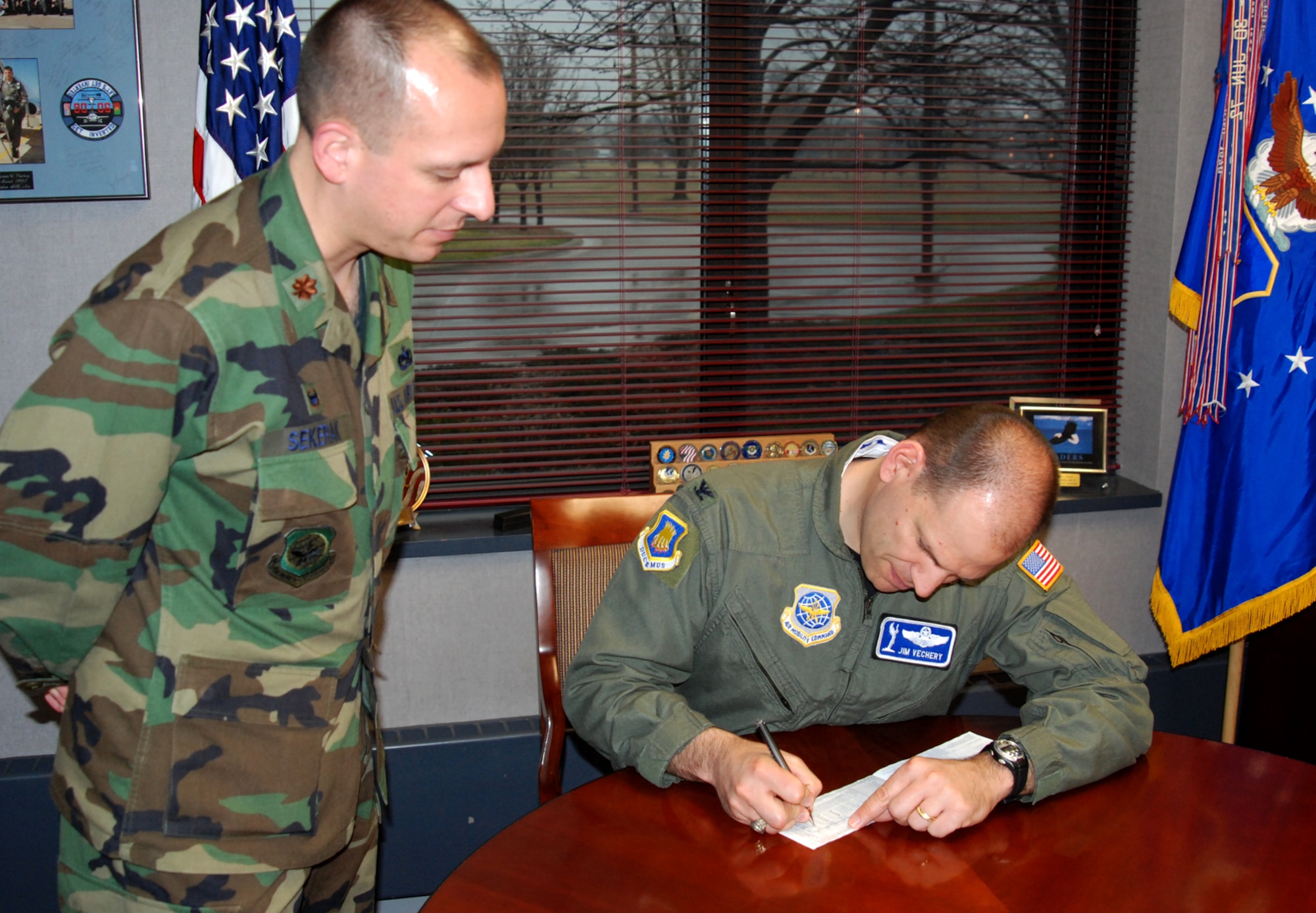 MCCONNELL AIR FORCE BASE, Kan. – Col. James Vechery, 22nd Air Refueling Wing commander, signs the first 2008 McConnell Air Force Assistance Fund pledge form for Maj. Edward Sekerak, Wing AFAF Campaign Officer, here, March 18. (photo by Airman 1st Class Jessica Lockoski) 