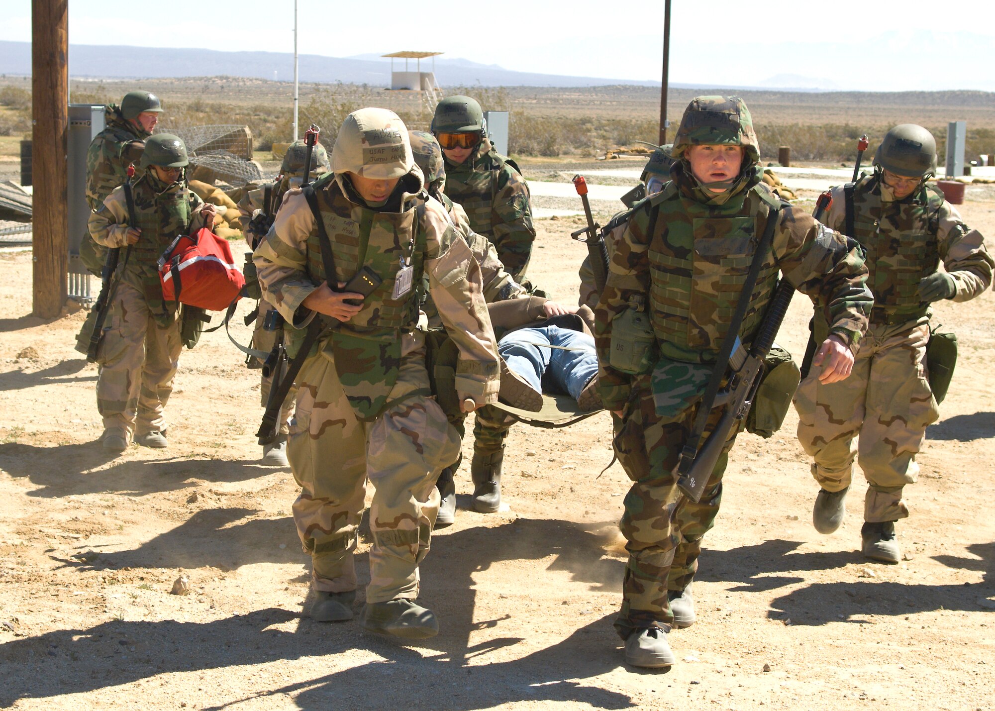 Edwards Airmen carry a litter March 12 at Camp Corum during the base's Phase II portion of the Operational Readiness Exercise here. Edwards held the ORE to test the base's ability to deploy Airmen downrange and then the Airmen's ability to survive and operate in a deployed location. (Air Force photo by Mike Cassidy)(Air Force photo by Mike Cassidy)