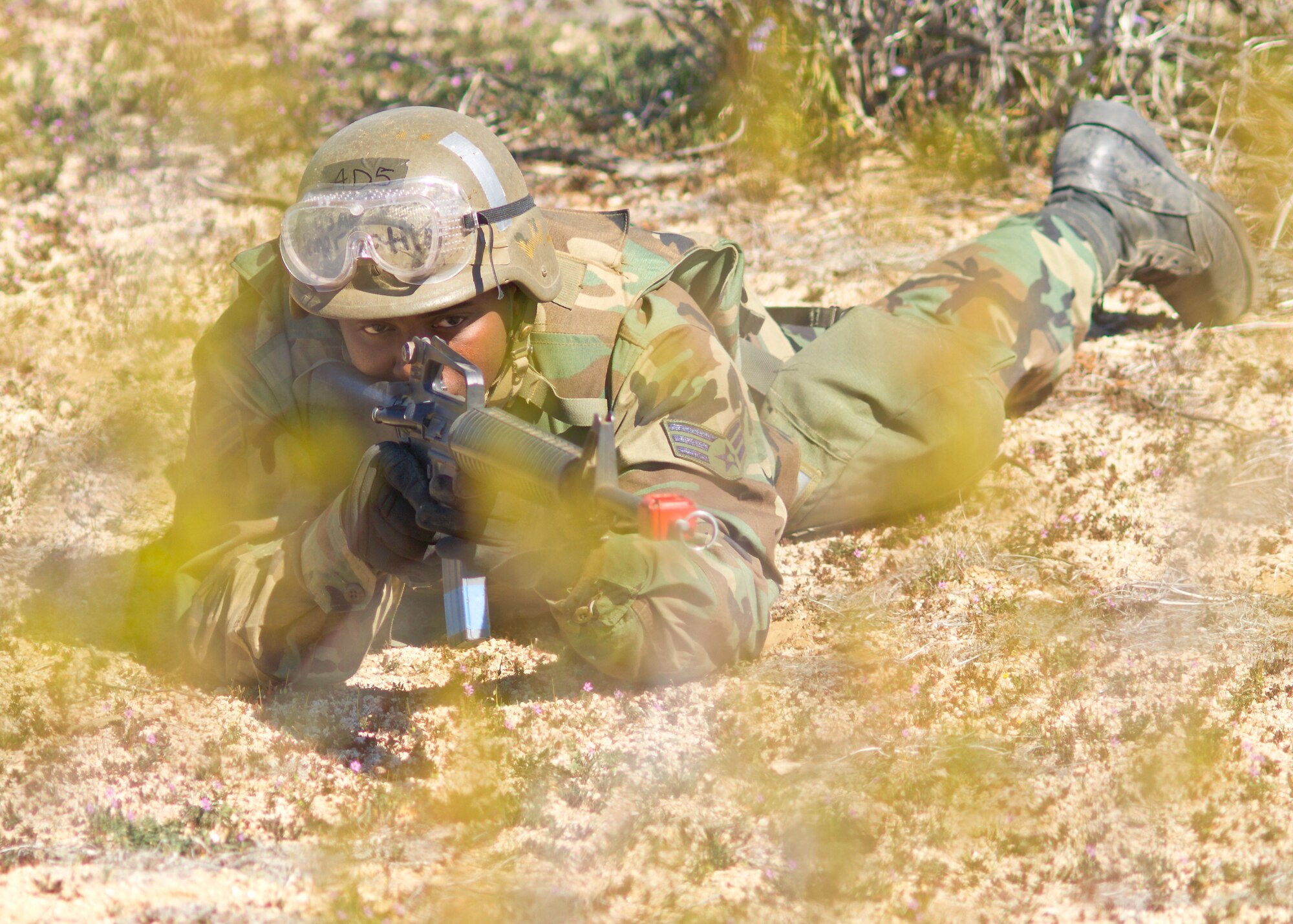 Senior Airman Jemar Battle, 95th Force Support Squadron assistant sports coordinator, aims his M-16 assault rifle March 12 while at Camp Corum here during the Phase II portion of the base's Operational Readiness Exercise. Edwards held the ORE to test the base's ability to deploy Airmen downrange and then the Airmen's ability to survive and operate in a deployed location.(Air Force photo by Mike Cassidy)