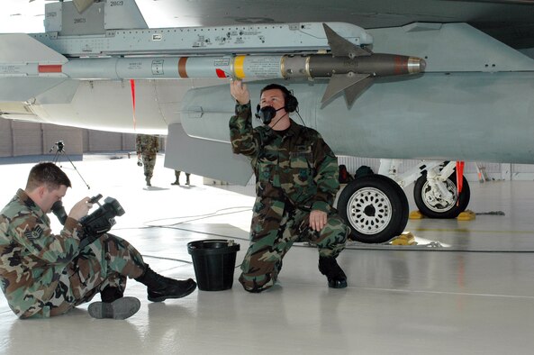 Staff Sgt. Henry Ivy (right), a crew chief with the alert detachment, runs through F-16 launch procedures while Staff Sgt. Pete Blanding, a videographer from Air Combat Command, records the process for training purposes. The film crew from Langley Air Force Base, Va., also captured the inner workings of recovery, pilot responsibilities, crew chief duties and de-arm procedures.
