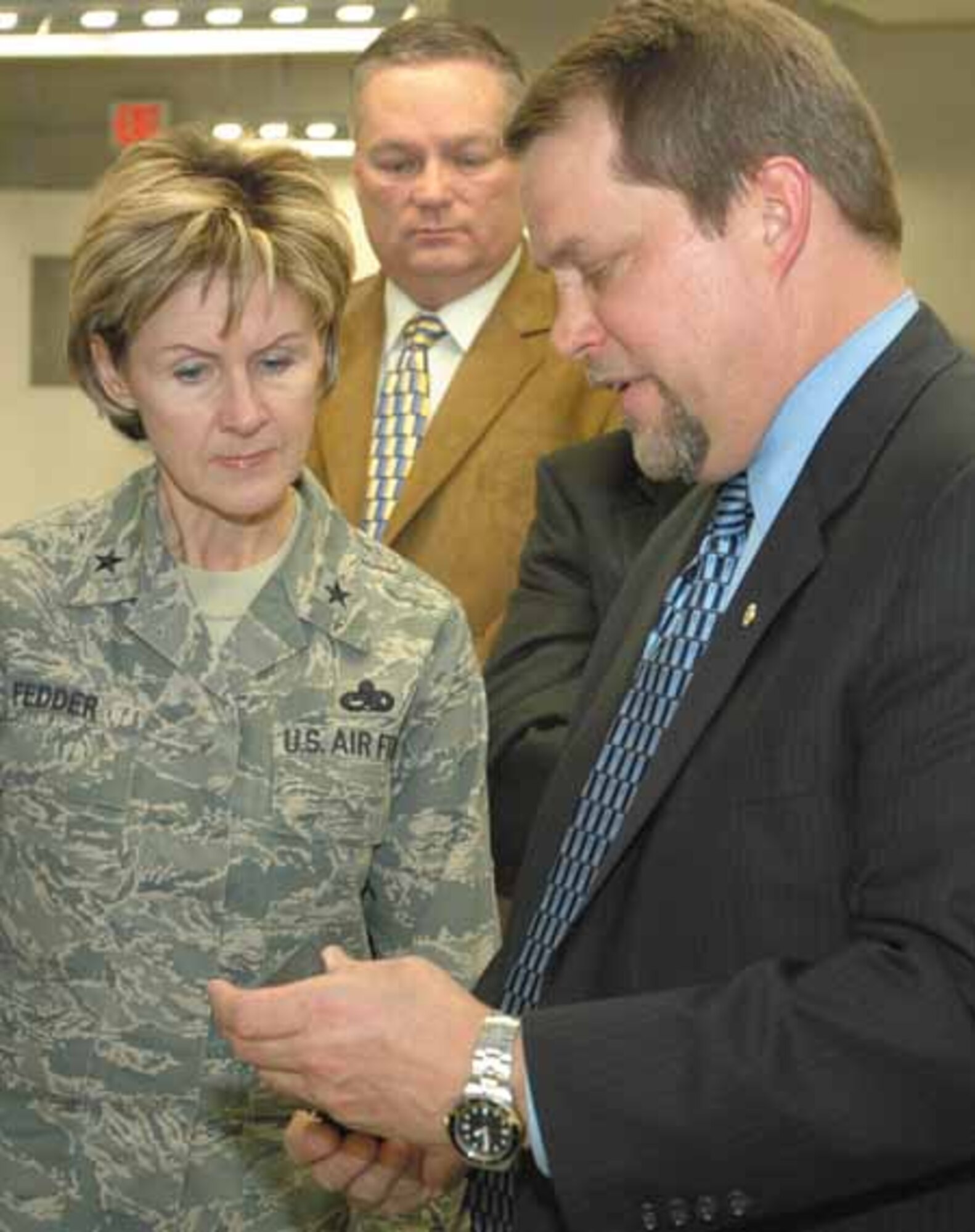 Chris Flynn, Pratt & Whitney F119 program director, shows a component from a F119
engine to Brig. Gen. Judy Fedder, 76th Maintenance Wing commander, following a ribbon cutting ceremony Mar. 11, formally opening a 8,200 square foot addition to the
Pratt & Whitney Heavy Maintenance Center in Bldg. 3001.  (Air Force photo by Ron Mullan)