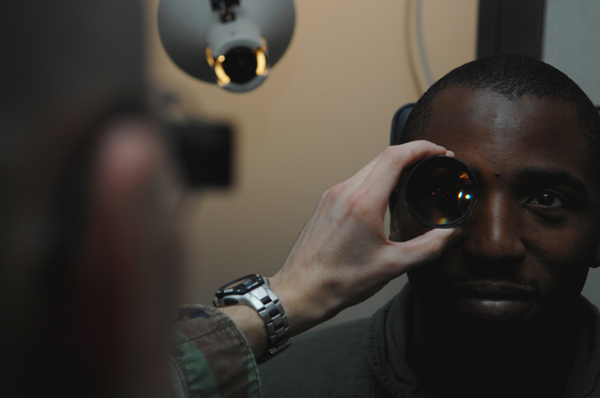 MOODY AIR FORCE BASE, Ga. – Capt. Nathan Anderson, 23rd Aerospace Dental Squadron optometrist, uses a binocular indirect ophthalmoscope to evaluate Staff Sgt. Mario McBride, 71st Rescue Squadron loadmaster, retina here March 4.  This retina evaluation is part of an annual eye exam that all military members receive. (U.S. Air Force photo by Senior Airman Angelita Lawrence) 