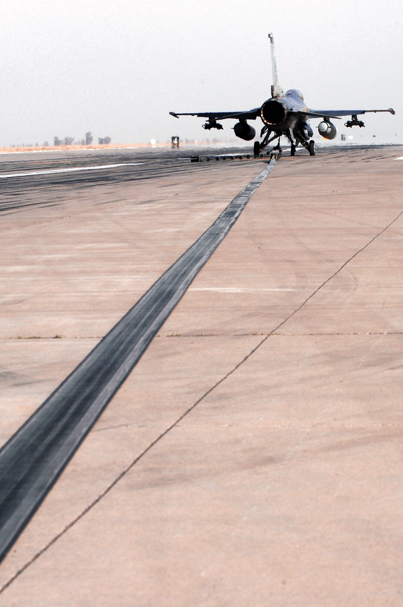 An F-16 Fighting Falcon catches an arresting cable during a certification test of the barrier system March 16 at Balad Air Base, Iraq. The system was installed by the 332nd Expeditionary Civil Engineer Squadron and is used to bring fighter aircraft to a smooth halt during emergency landings. (U.S. Air Force photo/Senior Airman Julianne Showalter) 
