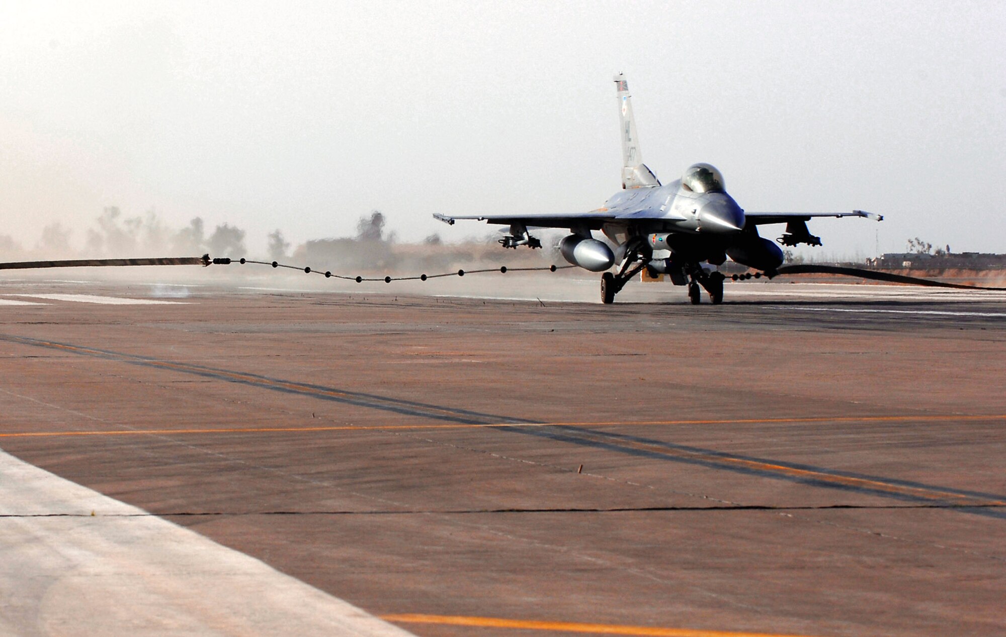An F-16 Fighting Falcon catches an arresting cable during a certification test of the system March 16 at Balad Air Base, Iraq. The system went through a certification test with an actual F-16 Fighting Falcon to ensure its operability following installation by the 332nd Expeditionary Civil Engineer Squadron. (U.S. Air Force photo/Senior Airman Julianne Showalter) 