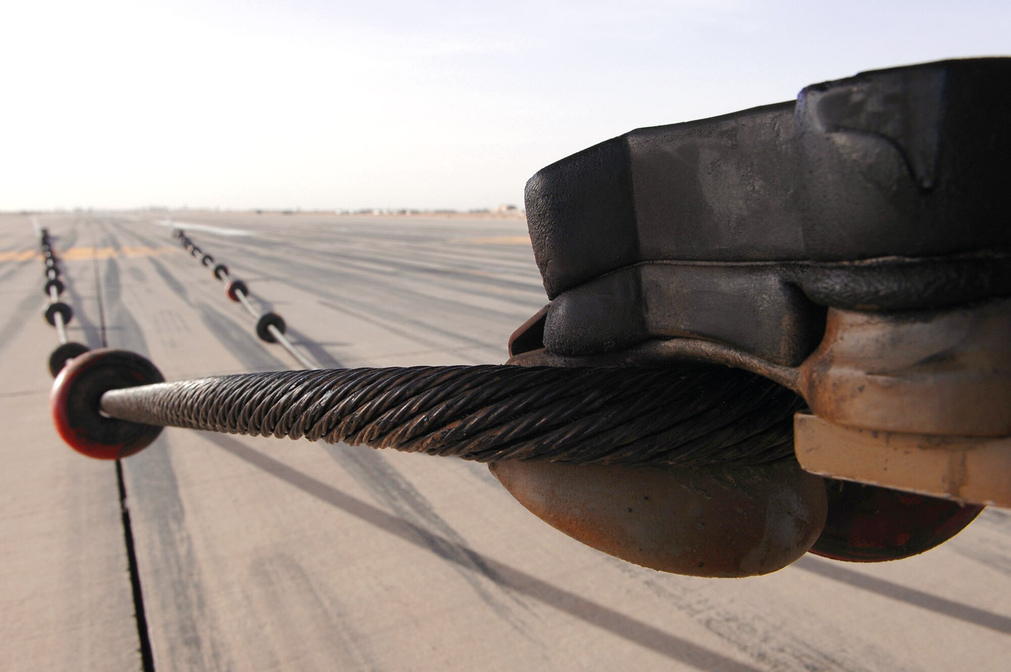 An F-16 Fighting Falcon waits to be disconnected from an emergency arresting barrier system cable after passing a certification test of the system March 16 at Balad Air Base, Iraq. The cable system, which is used to bring fighter aircraft to a smooth halt during emergency landings, stretched out about 400 feet before the aircraft came to a complete stop. (U.S. Air Force photo/Senior Airman Julianne Showalter) 