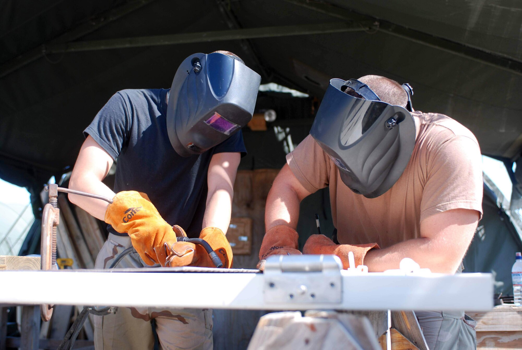 Senior Airman Nick Skinner and Staff Sgt. John Heiser weld a detainee cell door March 13 at Camp Justice on Guantanamo Bay, Cuba. Both are members of the 474th Expeditionary Civil Engineering Squadron, which broke ground on the complex Sept. 11, 2007, to construct the Expeditionary Legal Complex. Joint Task Force Guantanamo personnel conduct safe and humane care and custody of detained enemy combatants. (U.S. Army photo/Spc. Shanita K. Simmons)