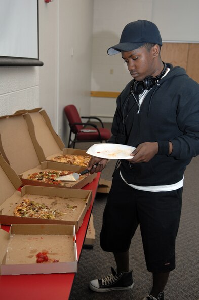 Airman 1st Class Jaamil Kirk, 49th Materiel Maintenance Squadron, goes up for a second helping of pizza at the Community Center on Holloman Air Force Base, N.M. Oasis Pizza provided free pizza to all of the students in the First Term Airmen Center program March 14. (U.S. Air Force photo/Airman Sondra Wieseler)