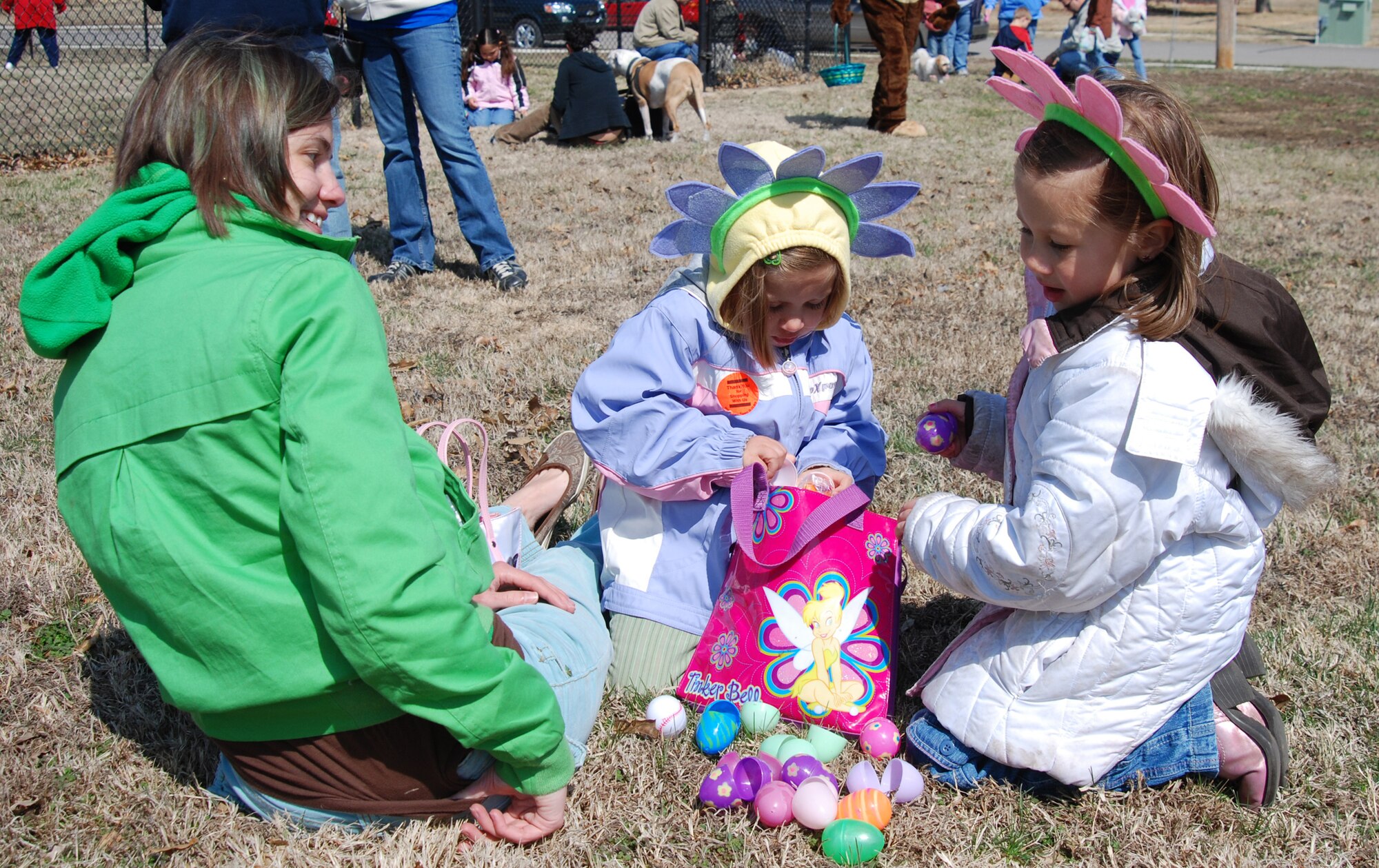 MCCONNELL AIR FORCE BASE, Kan. -- Kendra Owens, wife of Tech Sgt. Shawn Owens, 22nd Logistics Readiness Squadron, and their daughters, Hope, 4, and Hazel, 6, dig through a bag of colorful Easter eggs filled with candy March 15, after an Easter egg hunt at the McConnell Southwind baseball fields. (Photo by Airman 1st Class Jessica Lockoski)