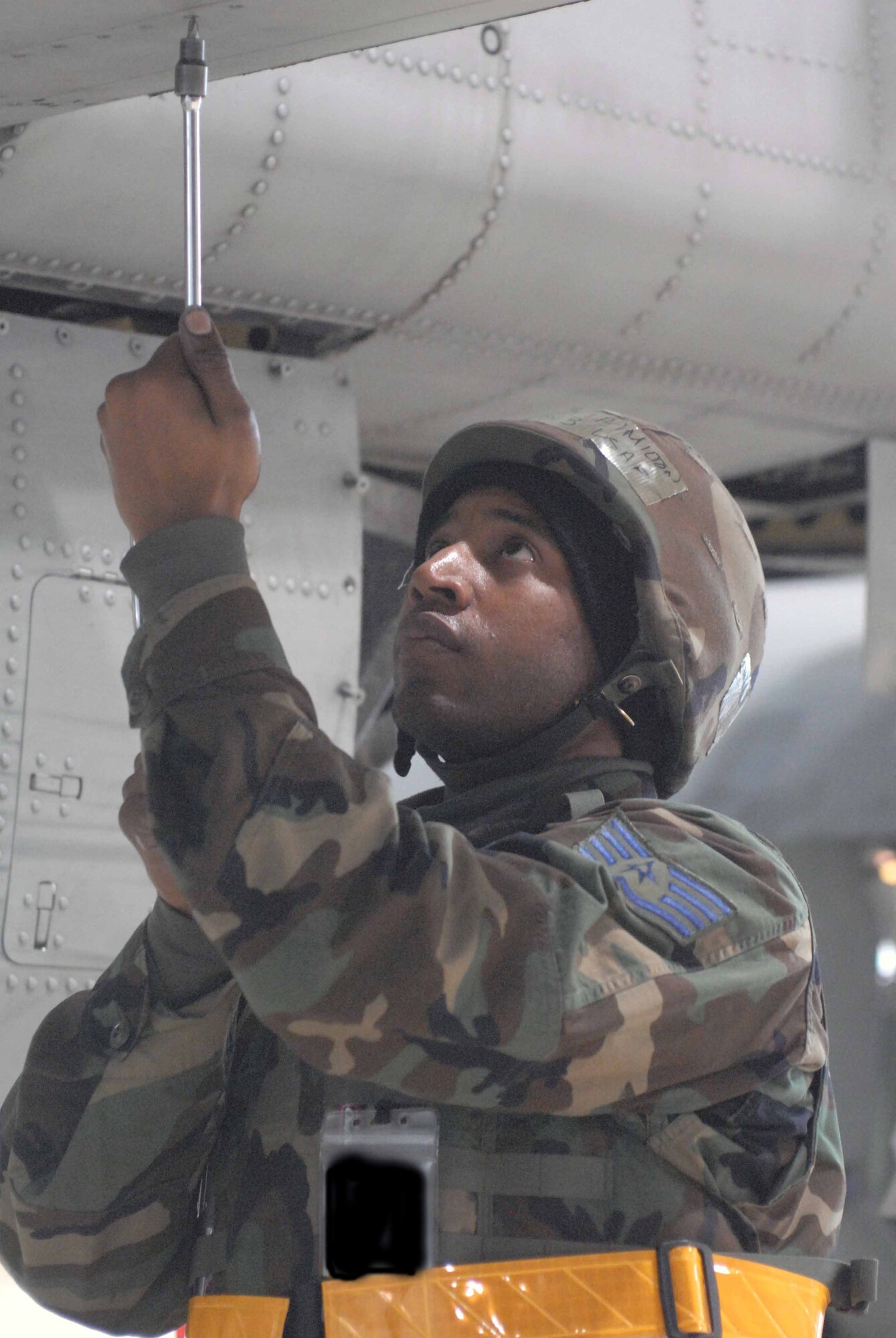 OSAN AIR BASE, Republic of Korea -- Staff Sgt. Vincent Hamilton, 25th Fighter Squadron crew chief, checks the fastner chips on an A-10 Thunderbolt II during Exercise Beverly Midnight March 18. (U.S. Air Force photo/Staff Sgt. Lakisha Croley) 
-- Image has been digitally altered