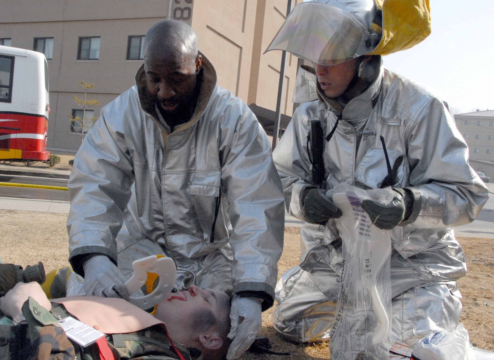 OSAN AIR BASE, Republic of Korea -- (From left to right) Staff Sgt. Jerod Leach and Staff Sgt. Karl Schnoes, 51st Civil Engineer Squadron fire fighters, secure Senior Airman Barry Wiles, 51st Aircraft Maintenance Squadron avionics journeyman, during a simulated bus explosion during the Beverly-Midnight Exercise March 17. (U.S. Air Force photo/Staff Sgt. Lakisha Croley)