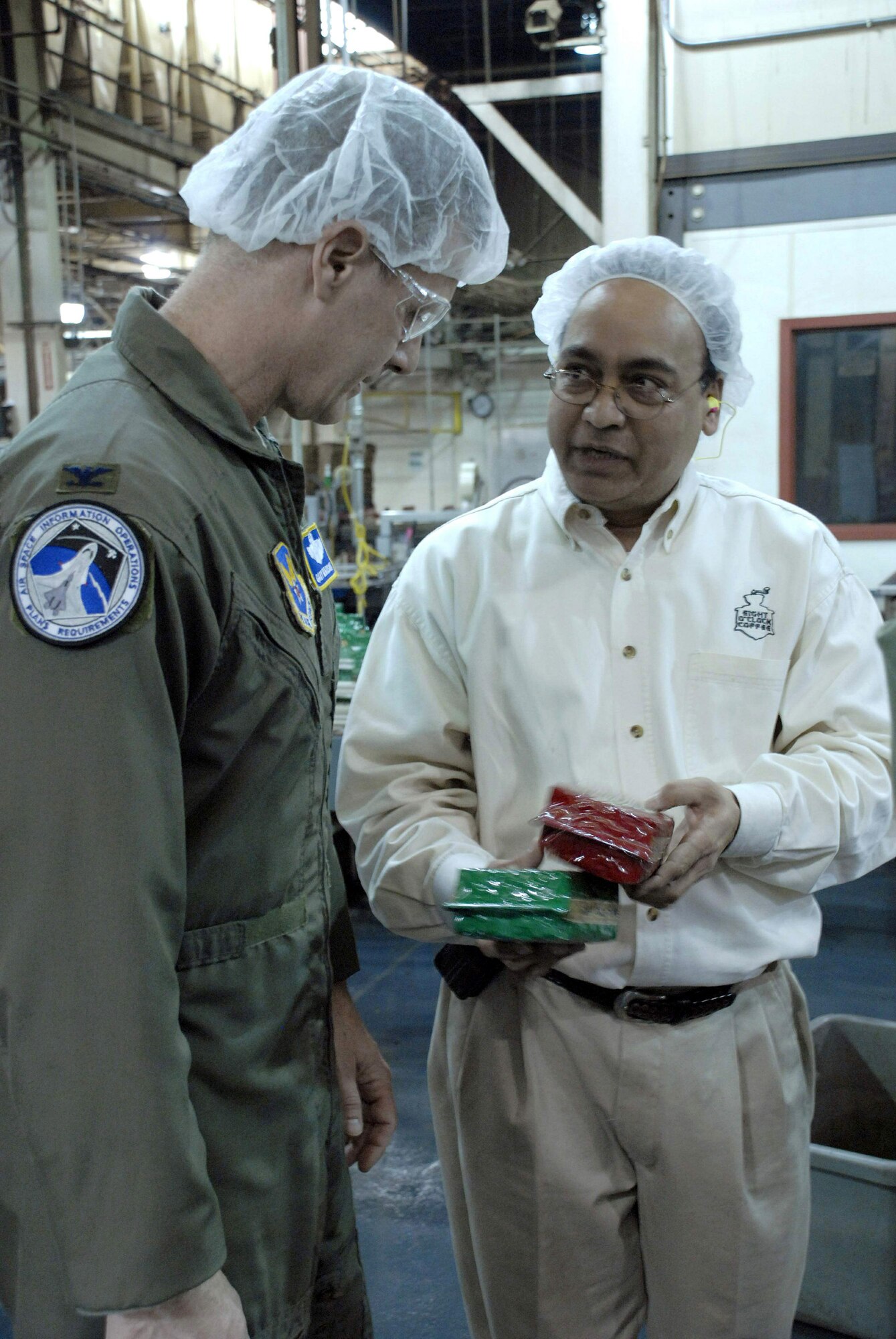 Col. Gary Mausolf and Janak Bhatt discuss coffee production during a tour of the company's production plant March 12 in Hyattsville, Md. A group of Air Force officers and senior NCOs from the Pentagon were at the company to gain insight as the company recently incorporated a program similar to Air Force Smart Operations for the 21st century into their work. Colonel Mausolf works on the Air Staff at the Pentagon, and Mr. Bhatt is an Eight O'Clock Coffee Company engineering manager. (U.S. Air Force photo/Staff Sgt. Julie Weckerlein) 
