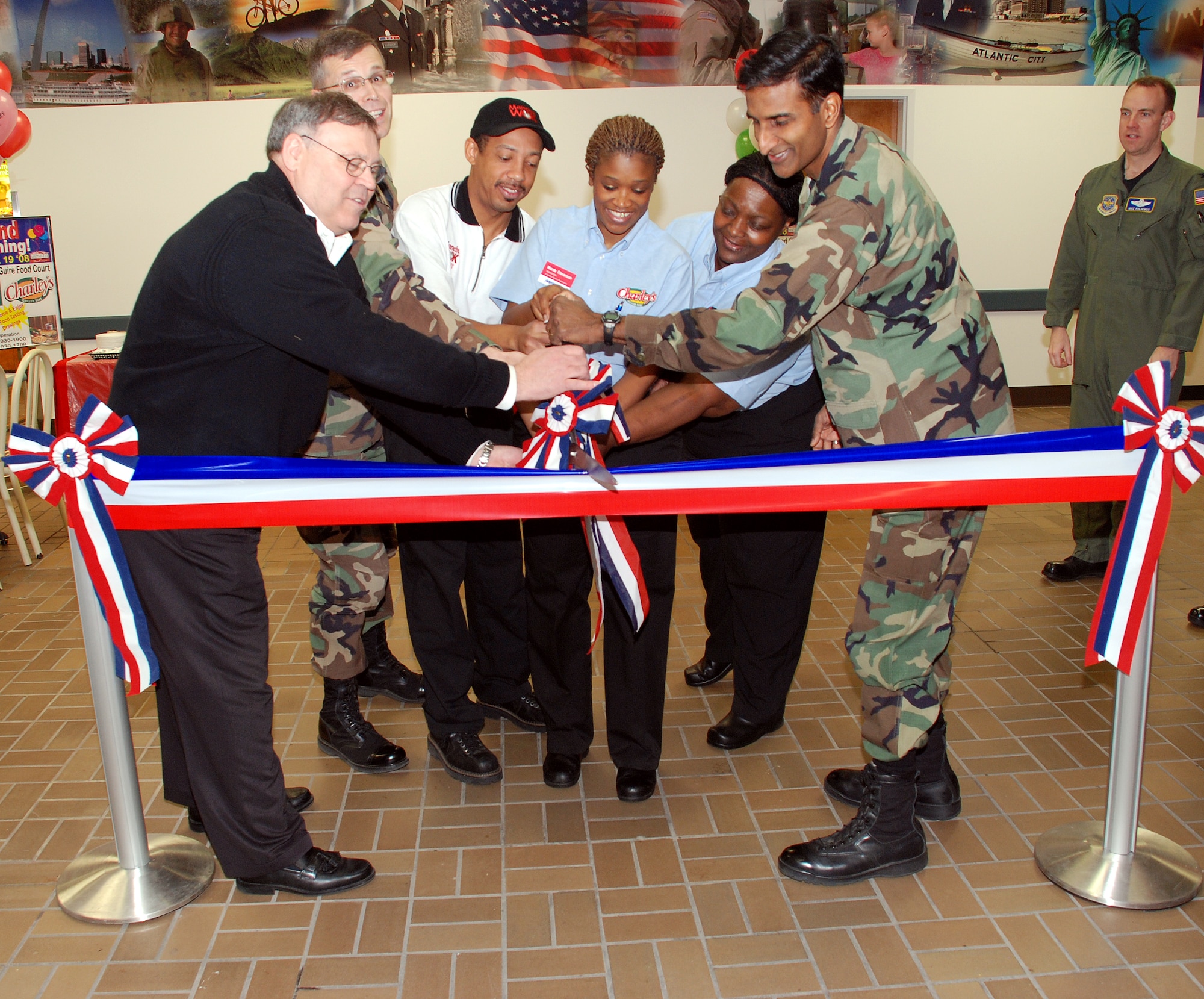 Col. Balan Ayyar, 305th Air Mobility Wing commander, and Col. Michael Hutchison, 305th Mission Support Group commander, help cut the ribbon at the Charley’s and Manchu Wok restaurants grand opening celebration in the Base Exchange here March 19. Peter Thieme, BX general manager, Wanda Stevenson, AAFES manager, and other BX staff also helped cut the ribbon. Colonel Ayyar thanked the BX staff for offering this great service to the Airmen, Soldiers and their families, who deserve it. Both eateries will be open Monday through Saturday, 10:30 a.m. to 7 p.m. and Sunday, 10:30 a.m. to 5 p.m. (U.S. Air Force photo/Airman 1st Class Rebekah Phy)