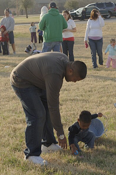 DYESS AIR FORCE BASE, Texas -- Mr. Brian Lewis, 7th Operations Support Squadron, helps his son, Isaiah, by pointing to an Easter egg during the ?Breakfast with the Bunny and Easter Egg Hunt? hosted by the 7th Services Squadron.  More than children came out the morning of March 16 to enjoy hunting eggs in the parade field in front of the base commissary.  (U.S. Air Force photo by Staff Sergeant Connor W. Estes)
