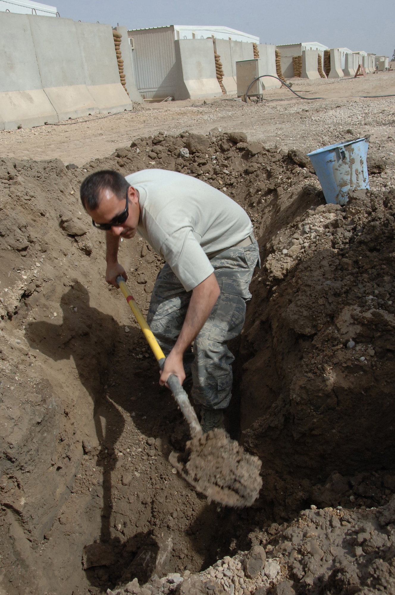 ALI BASE, Iraq ? Senior Airman Richard Perez of the 407th Expeditionary Civil Engineering Squadron, digs a hole around a pipe to repair a busted sewage line in tent city March 19.    Airman Perez is a utility sysems journeyman deployed from Eielsen AFB, Alaska.  (U. S. Air Force photo / Tech. Sgt. Sabrina Johnson)