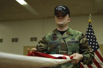 MINOT AIR FORCE BASE, N.D. -- Senior Airman Sean Godwin, 5th Munitions Squadron, folds a flag to practice on flag folding ceremonies, March 14. The flag folding ceremony is one of the tasks the base honor guard is required to perform. (U.S. Air Force photo by Airman First Class Jesse Lopez)
