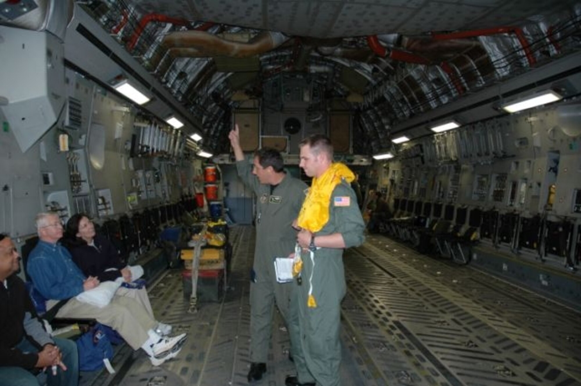 Staff Sgt. Gus Morse, a reservist with the 317th Airlift Squadron at Charleston AFB, S.C., gives a passenger safety and demonstrates the life preserver for over water flights under the direction of Senior Master Sgt. Dean Carter, also with the 317 AS. (Photo by 2nd Lt. Holly Carlisle, USAFR)
