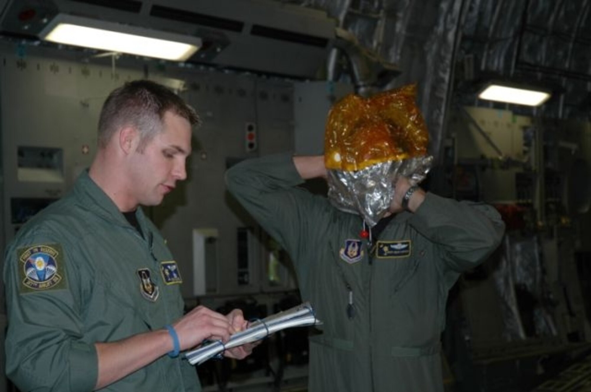 Staff Sgt. Gus Morse, a reservist with the 317th Airlift Squadron at Charleston AFB, S.C., gives a passenger safety briefing under the watchful eye of Senior Master Sgt. Dean Carter, also with the 317 AS, who is demonstrating the donning procedures for the emergency passenger oxygen system. (Photo by 2nd Lt. Holly Carlisle, USAFR)
