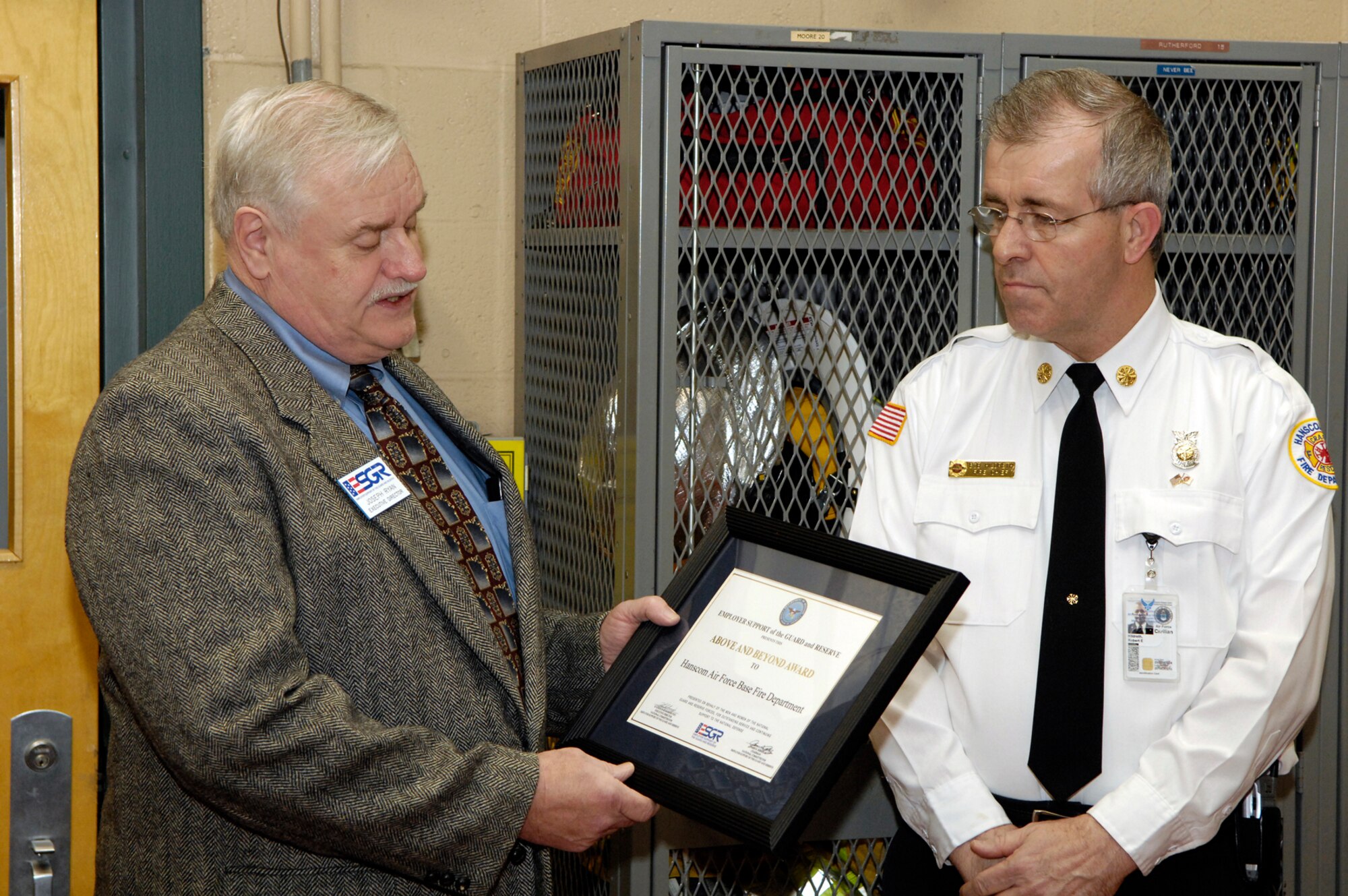 HANSCOM AFB, Mass. – Joe Ryan (left), Employee Support for the Guard and Reserve, executive director, presents Bob Hildreth (right), Hanscom Fire Department, fire chief with the ESGR Above and Beyond award on March 17. The award recognizes American employers who provide extraordinary patriotic support and cooperation to their employees. Tech. Sgt. James Robbins, a reservist and fire department employee nominated the department for the award.  (U.S. Air Force photo by Mark Wyatt)