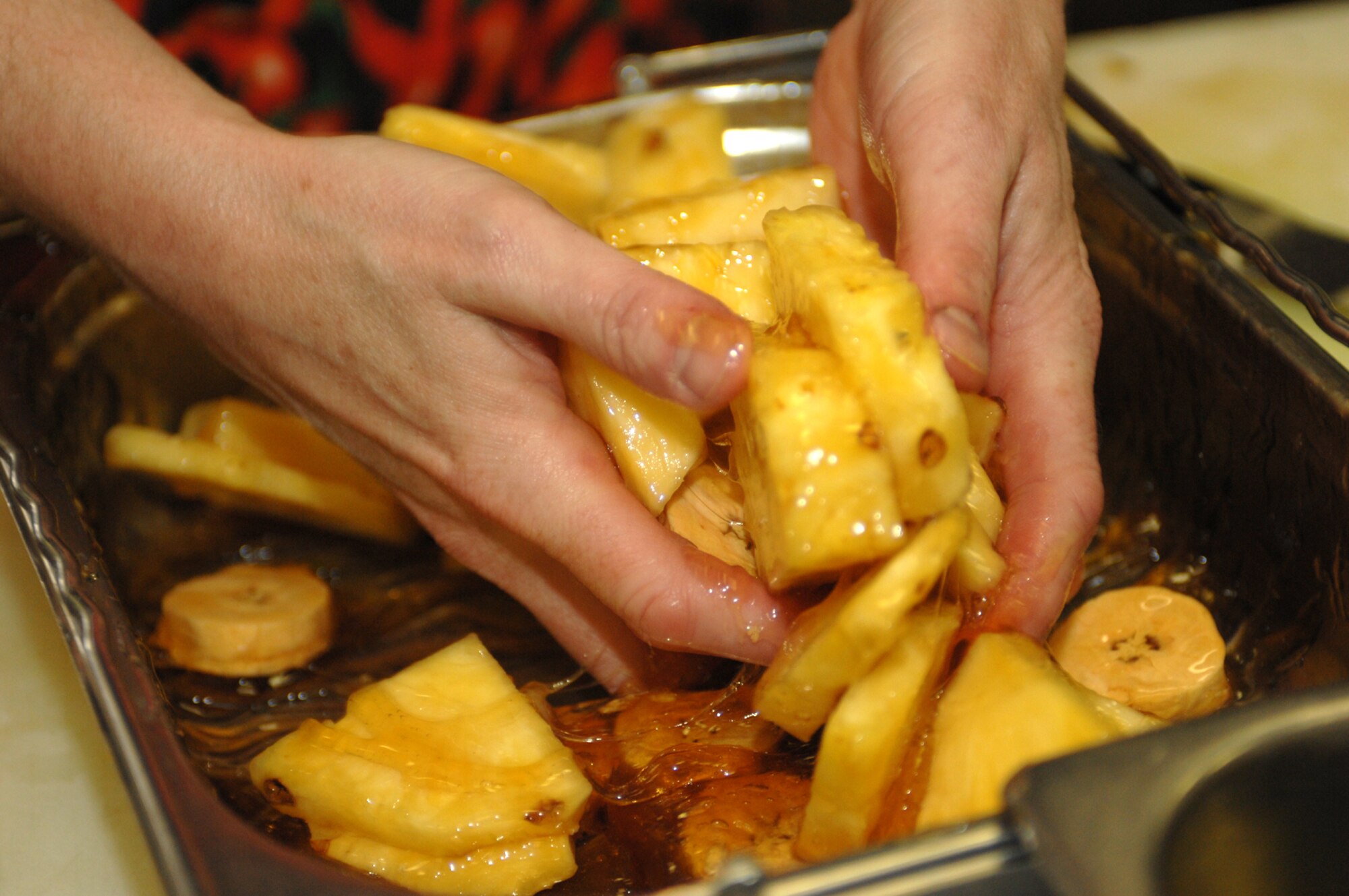 SPANGDAHLEM AIR BASE, Germany -- Master Sgt. Diane Jernigan, 52nd Dental Squadron, hand-mixes pineapples and plantains with honey during the Iron Chef competition held by the 52nd Services Squadron, March 14, 2008. (U.S. Air Force photo/Staff Sgt. Kristin Ruleau)