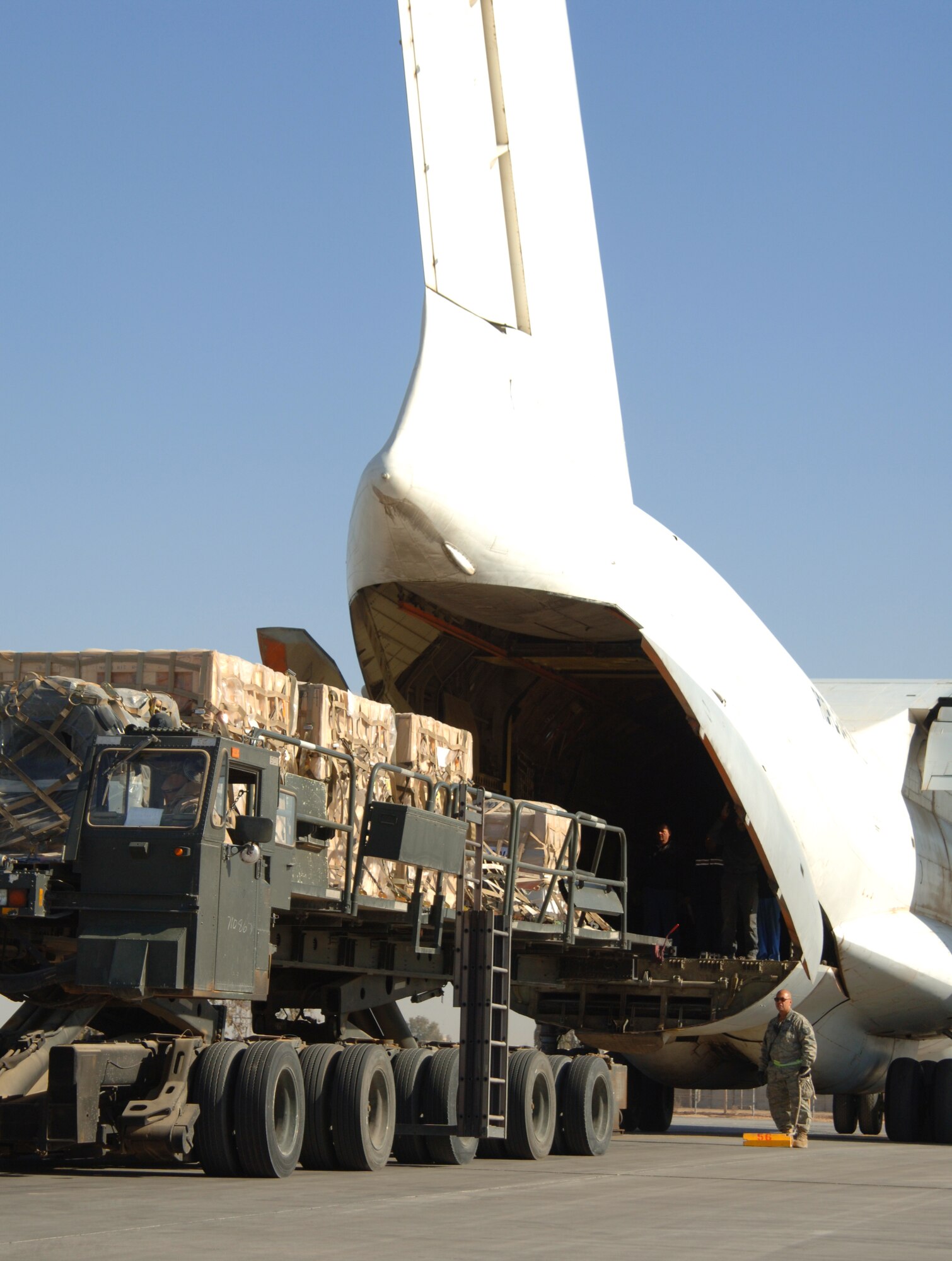 BALAD AIR BASE, Iraq -- Tech. Sgt. Peter Aguilar, 332nd Expeditionary Logistics Readiness Squadron aerial port flight ramp service technician, guides a 60K tunner as it prepares to unload a Russian AN-124 aircraft. Sergeant Aguilar is a deployed reservist from the 88th Aerial Port Squadron at McGuire Air Force Base, N.J.(U.S. Air Force photo/ Master Sgt. Heather Cabral)  