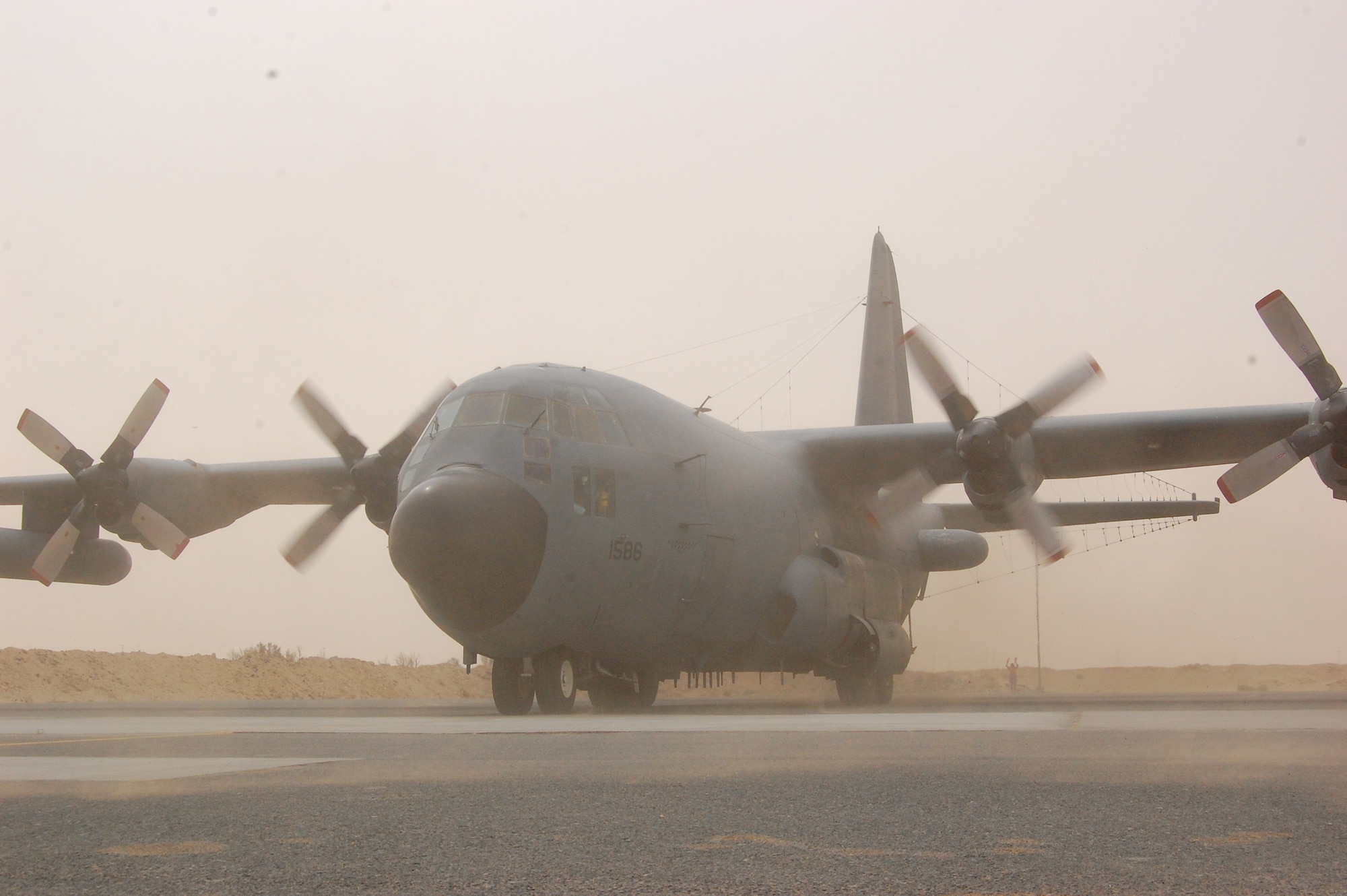 SOUTHWEST ASIA – The 4,591 prop shaft horsepower of two Allison T56-A-15 turboprops kicks up dust and pebbles from the parking ramp during an EC-130H Compass Call reverse engine thrust as it backed into position at an air base in the Persian Gulf Region March 18, 2008. Aircraft tail number 1586 is deployed from the 55th Electronic Combat Group out of Davis-Monthan Air Force Base, Ariz., and was flown on the 43rd Expeditionary Electronic Combat Squadron’s 2,276th combat sortie marking the Arizona-based unit’s fourth consecutive year deployed supporting the Global War on Terror. (Air Force photo/Tech. Sgt. Michael O’Connor)