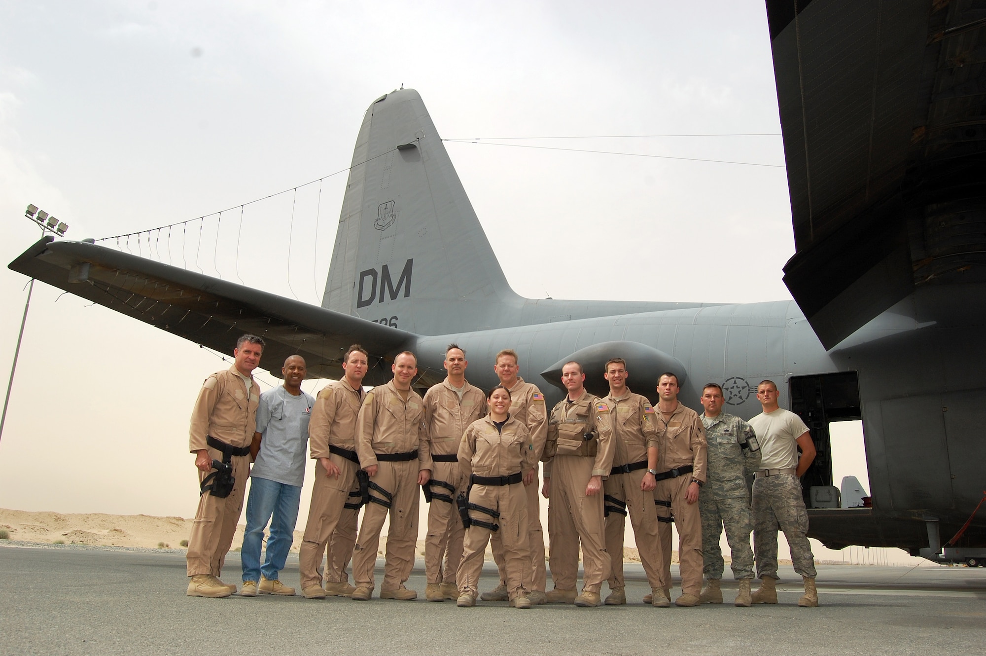 SOUTHWEST ASIA -- Two Airmen and one civilian contractor from the 386th Expeditionary Aircraft Maintenance Squadron pause for a group photo with a nine-person aircrew from the 43rd Expeditionary Electronic Combat Squadron following the completion of a mission on March 18, 2008 at an air base in the Persian Gulf Region. The flying unit’s historic 2,276th combat sortie came on the four-year anniversary of the 43rd EECS being consecutively deployed supporting the Global War on Terror. The aircrew and maintenance personnel are deployed from Davis-Monthan Air Force Base, Ariz. (Air Force photo/Tech. Sgt. Michael O’Connor)