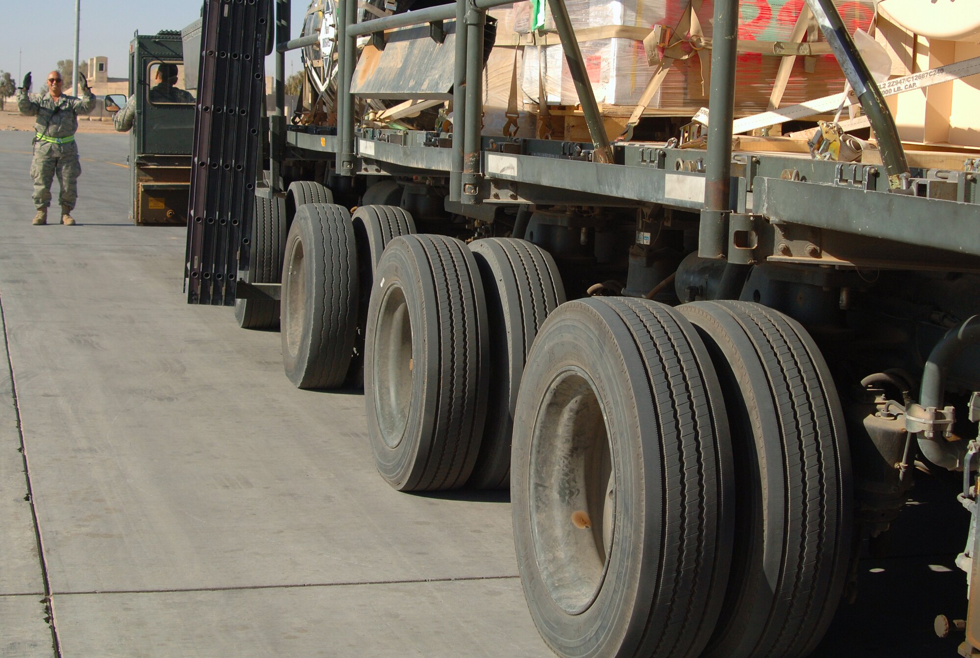 BALAD AIR BASE, Iraq -- Tech. Sgt. Peter Aguilar, 332nd Expeditionary Logistics Readiness Squadron aerial port flight ramp service technician, spots a 60K tunner as it leaves the cargo yard here. Sergeant Aguilar is a deployed reservist from the 88th Aerial Port Squadron at McGuire Air Force Base, N.J.(U.S. Air Force photo/ Master Sgt. Heather Cabral) 