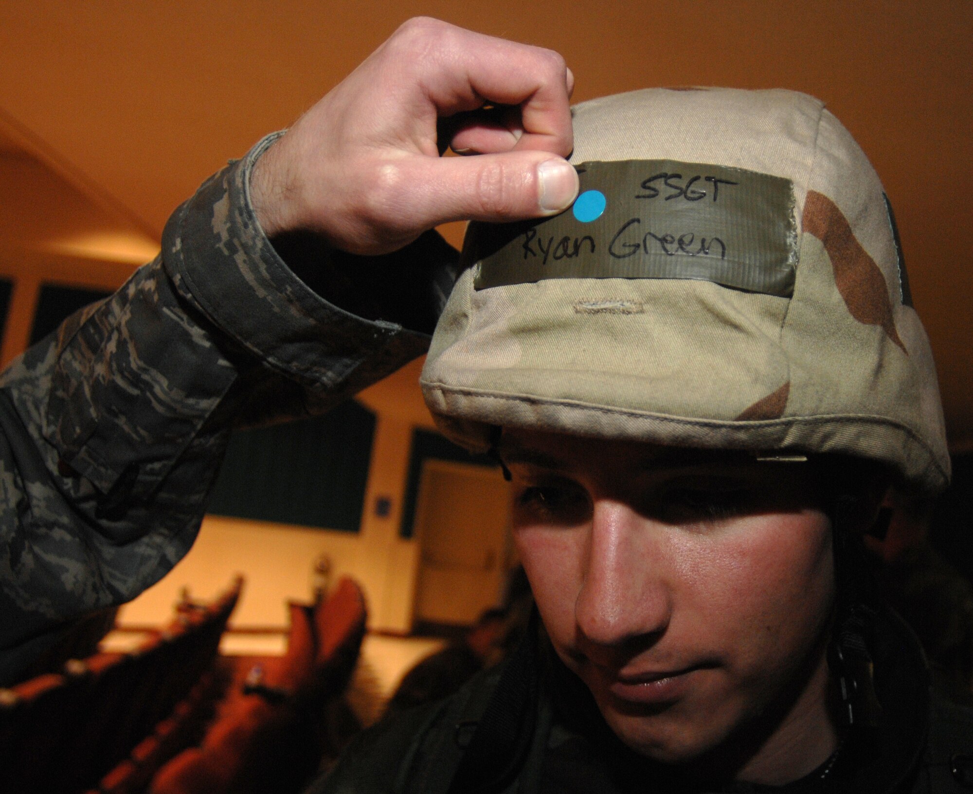 MOUNTAIN HOME AIR FORCE BASE, Idaho -- Staff Sgt. Ryan Green, 391st Aircraft Maintenance Unit crew chief, gets a blue sticker put on his helmet during Exercise Coronet White 08-ACC-14 March 16.  The blue sticker represents his transition through the toxic free area before he starts his shift.  The 366th Fighter Wing is participating in an Operational Readiness Inspection March 13-21 to test the wing's ability to deploy and take its mission to war. (U.S. Air Force photo by Airman 1st Class Stephany Miller)