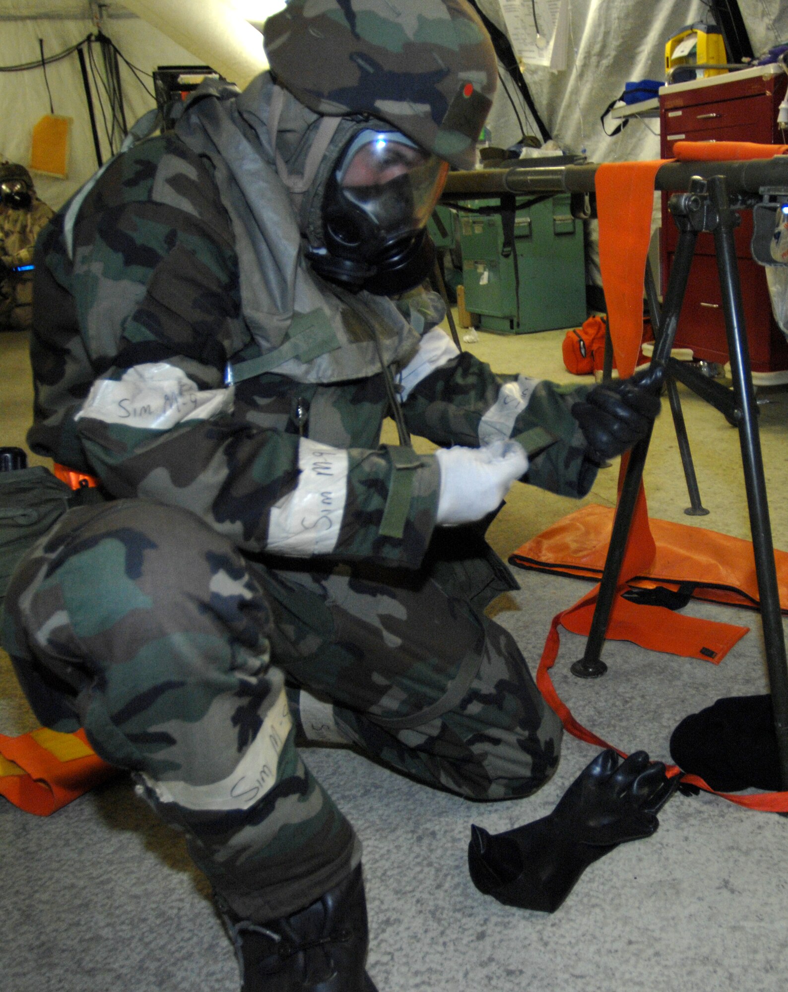 MOUNTAIN HOME AIR FORCE BASE, Idaho -- Senior Airman Jack Williams, 366th Medical Operations Squadron medical technician, puts on his chemical warfare suit after hearing the chemical attack siren during Exercise Coronet White 08-ACC-14 March 16. The 366th Fighter Wing is participating in an Operational Readiness Inspection March 13-21 to test the wing's ability to deploy and take its mission to war. (U.S. Air Force photo by Airman 1st Class Stephany Miller)