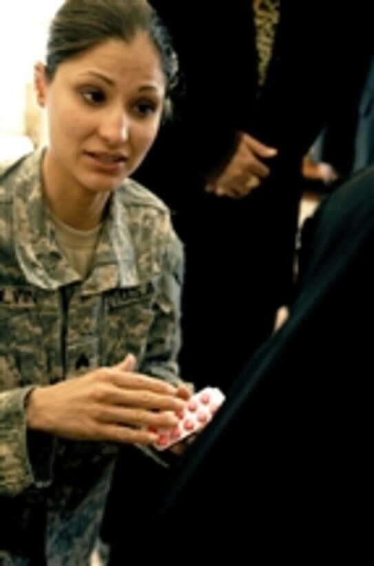 U.S. Army Sgt. Karina Colvin, a medic from Charlie Company, 225th Brigade Support Battalion, 2nd Stryker Combat Brigade Team, 25th Infantry Division, dispenses medication to a patient during a combined medical effort in Bata, Iraq, on March 17, 2008.  