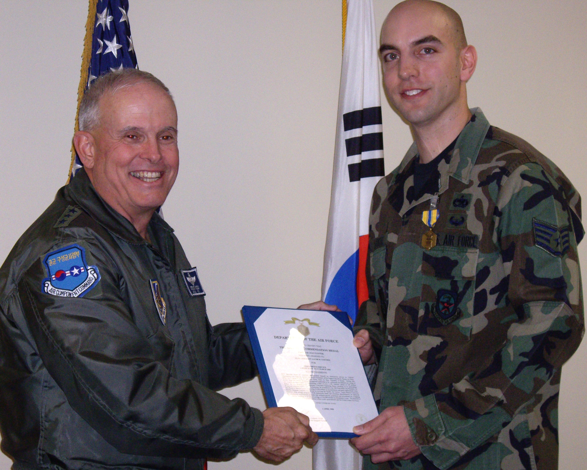 DAEGU AIR BASE, Republic of Korea -- Lt. Gen. Stephen G. Wood, commander 7th Air Force presents the Air Force Commendation Medal to Staff Sergeant Jacob M. Sanchez at Daegu Air Base, the largest co-located operating base in Korea. Sergeant Sanchez works in vehicle management and analysis quality assurance with the 607th Support Squadron where he oversees a fleet of 1,100 vehicles valued at 148 million dollars for two geographically separated co-located operating bases. Among his many accomplishments, Staff Sergeant Sanchez is responsible for recovering $22,000 dollars in reconstitution and parts replacements costs, as well as saving $330,000 annually in maintenance costs.  (U.S. Air Force photo)