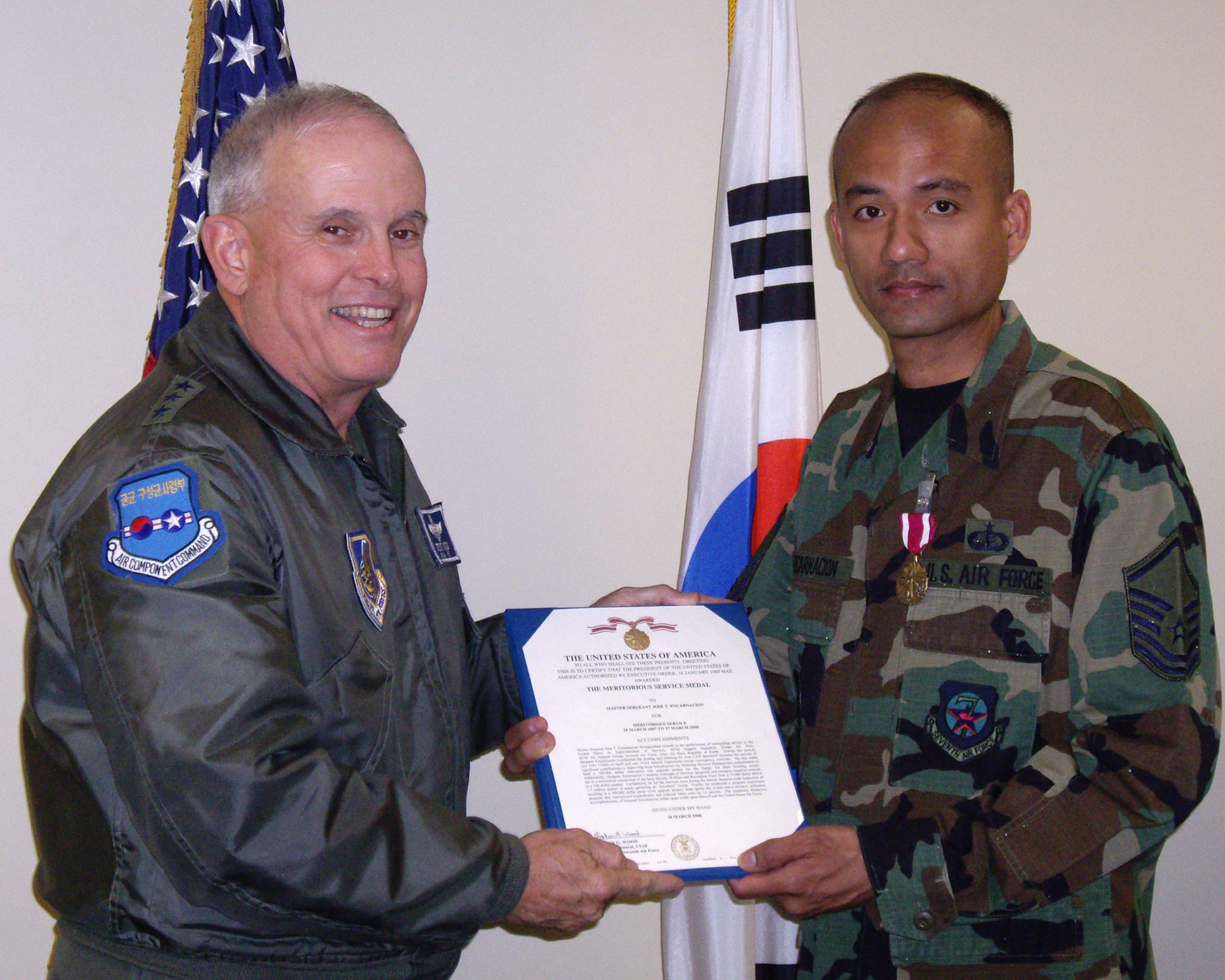 DAEGU AIR BASE, Republic of Korea -- Lt. Gen. Stephen G. Wood, commander 7th Air Force presents the Air Force Meritorious Service Medal to Master Sergeant Jose T. Encarnacion, Services superintendent for the 607th Support Squadron at Daegu Air Base, the Air Force's largest co-located operating base in Korea. From building renovations to morale, welfare and recreation events, Master Sergeant Encarnacion lead numerous programs valued at hundreds of thousands of dollars, improving MWR and readiness at Daegu.  (U.S. Air Force photo)