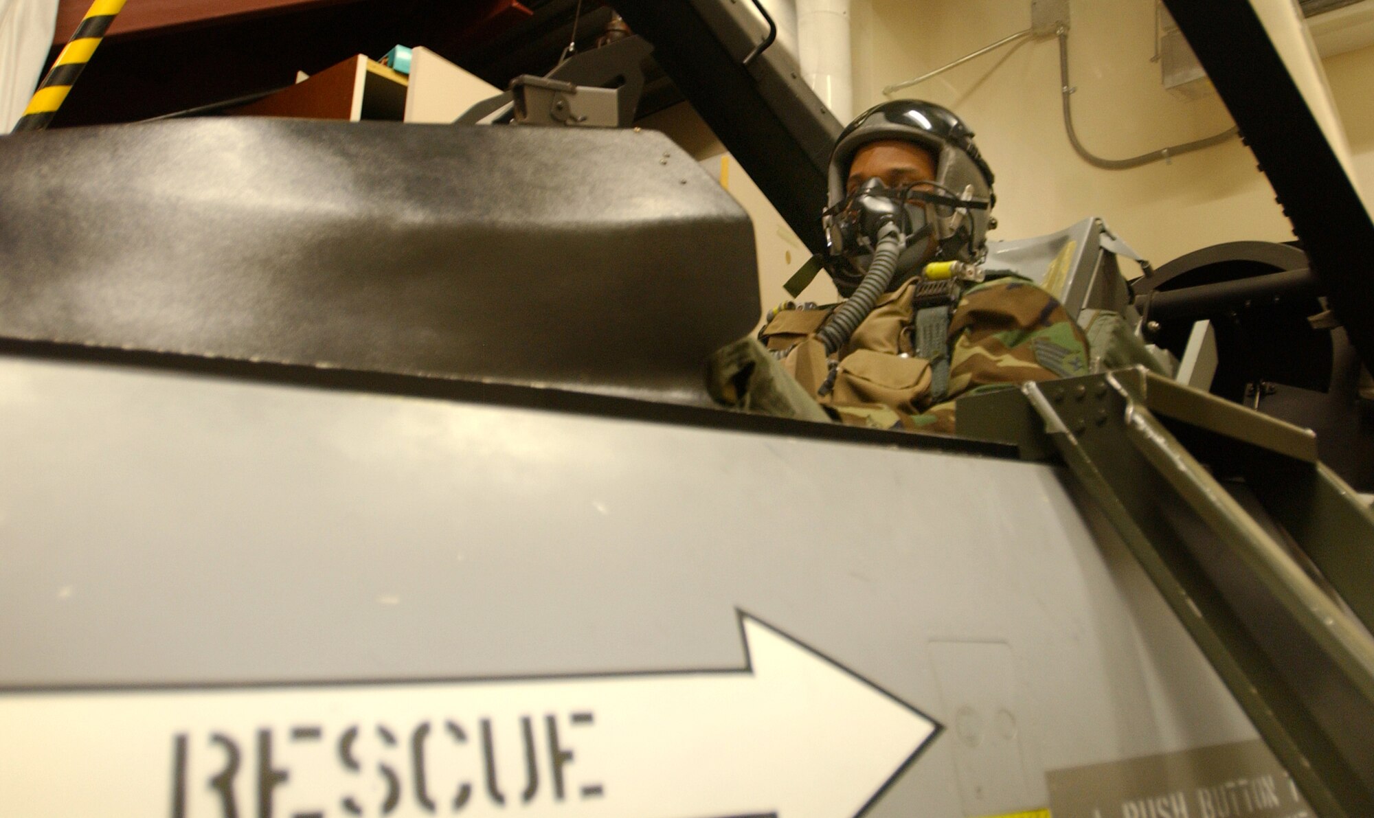 Staff Sgt. Eric Sheler familiarizes the inside of a cockpit simulator while awaiting egress training at the 18th Aggressor Squadron March 19, 2008. Sergeant Sheler was guided through the procedures of how to properly evacuate an aircraft in case of an emergency prior to documenting the combat training missions for Eielson. Sergeant Sheler is a still photographer assigned to the 354th Fighter Wing Public Affairs office. Major Flick is a pilot assigned to the 18th AGRS.  (U.S. Air Force photo by Airman 1st Class Christopher Griffin)