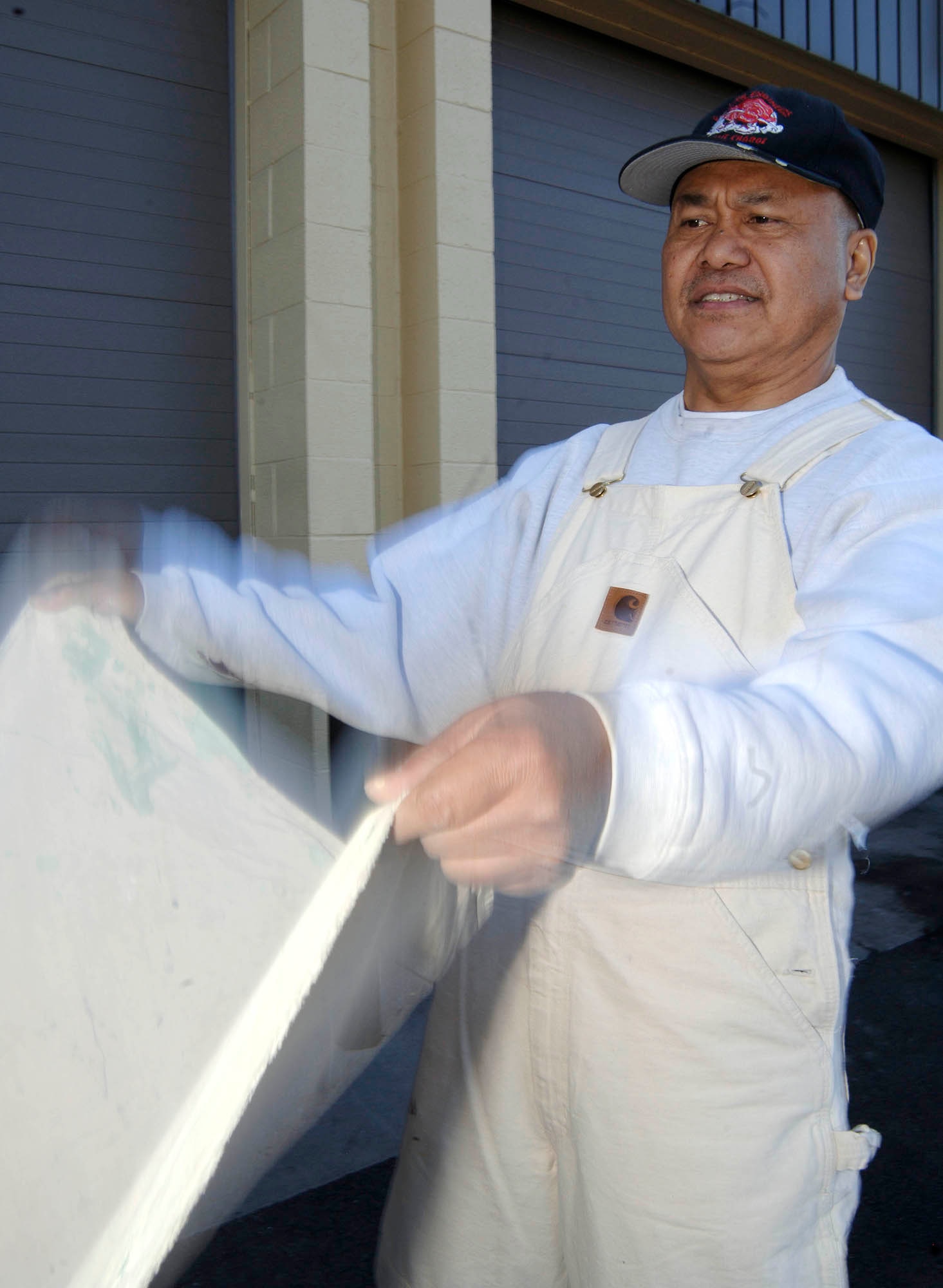 FAIRCHILD AIR FORCE BASE, Wash. – Chito Nacion, 92nd Civil Engineer Squadron painter, applies a drop cloth around the auto hobby shop March 18. The drop cloth ensures paint splatter and spills are kept to a minimum. (U.S. Air Force photo/Staff Sgt. JT May III)