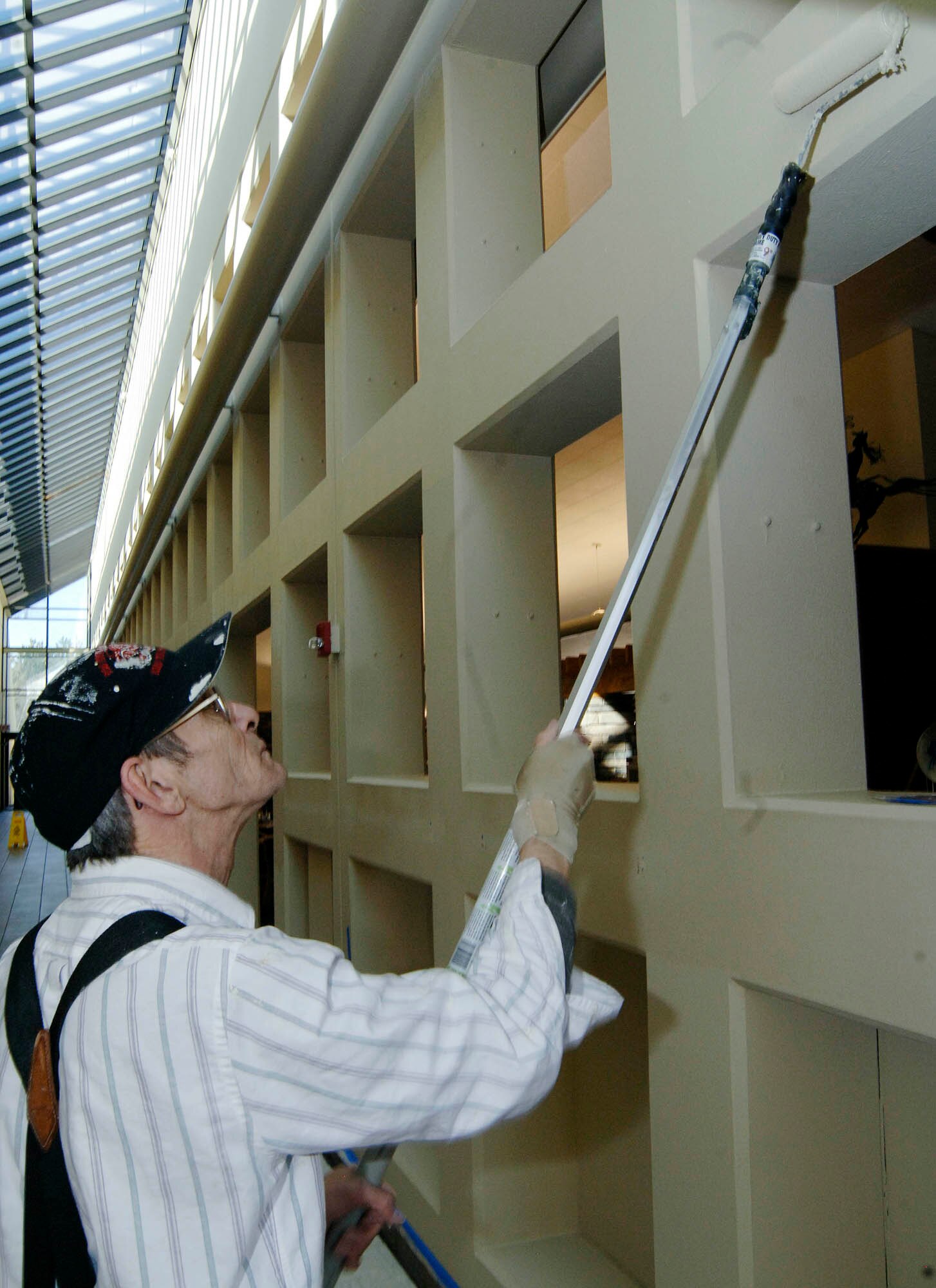 FAIRCHILD AIR FORCE BASE, Wash. – Charlie Crocket, 92nd Civil Engineer Squadrn painter, paints the interior of the Warrior Dining Facility March 18. Mr. Crocket is improving aesthetics while providing a better atmosphere for our military members. (U.S. Air Force photo/Staff Sgt. JT May III)