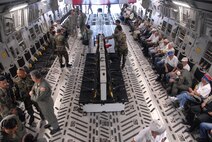 HICKAM AIR FORCE BASE, Hawaii -- Veterans from the 442nd Regimental Combat Team and the 100th Infantry Battalion (seated on the right) get seated and strapped in for a long waited incentive flight aboard the “Spirit of Go For Broke” one of Hickam’s C-17 Globemaster III aircraft that was named in honor of the men and their motto.  The soldiers of “Go For Broke” were composed entirely from volunteers of “Nisei “ second generation Japanese Americans. (U.S. Air Force photo/Tech. Sgt. Tom Czerwinski)