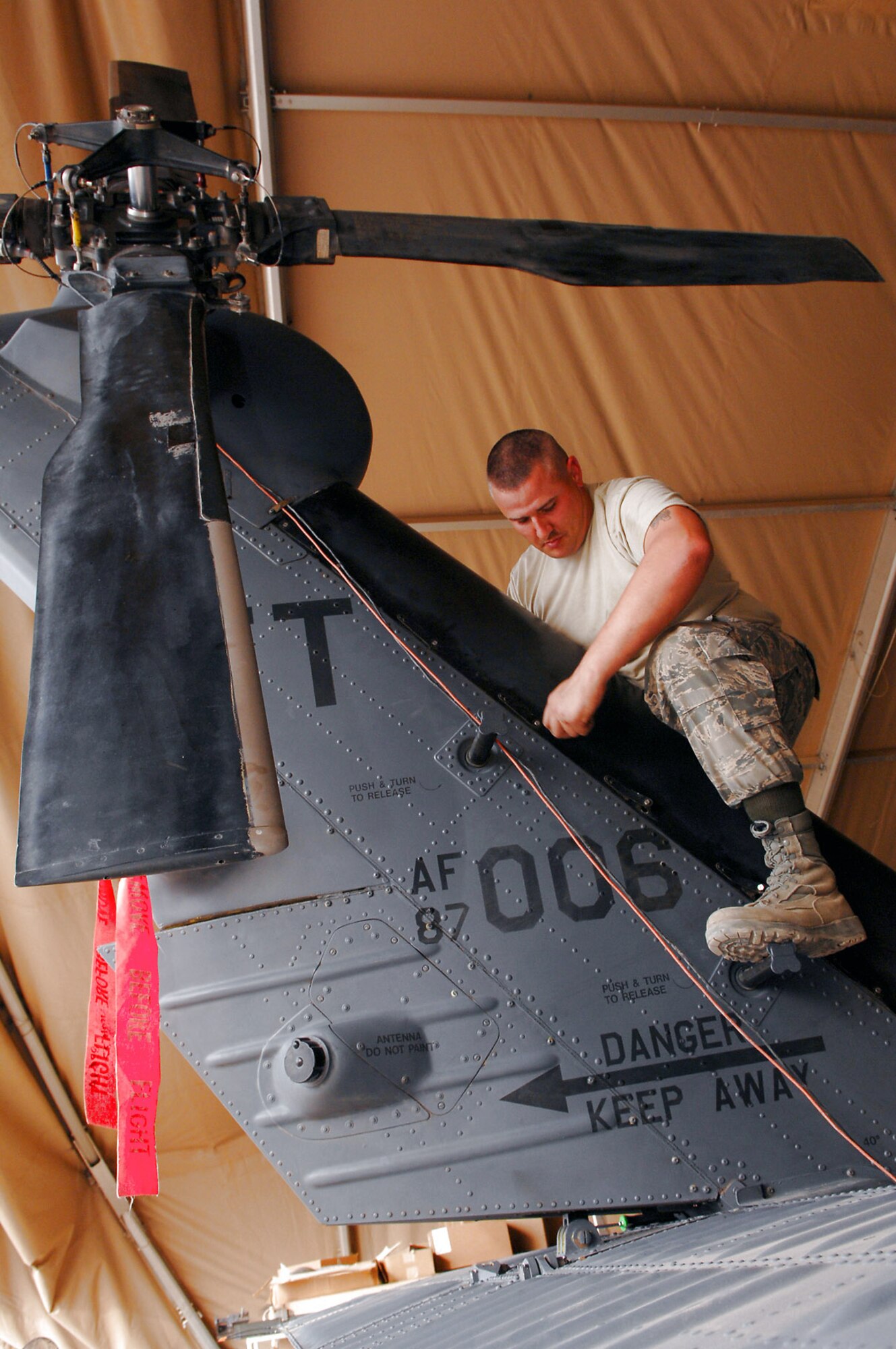 Staff Sgt. Tait Delzer tightens down the drive shaft cover of an HH-60 Pave Hawk helicopter March 12 at Balad Air Base, Iraq.   Sergeant Delzer, a crew chief with the 64th Expeditionary Helicopter Maintenance Unit, performed an inspection on the aircraft after it had been flown 300 hours. During the inspection, all of the panels and covers were removed to facilitate preventative maintenance on the aircraft's systems and equipment. Sergeant Delzer is deployed from Moody Air Force Base, Ga. (U.S. Air Force photo/Senior Airman Julianne Showalter)