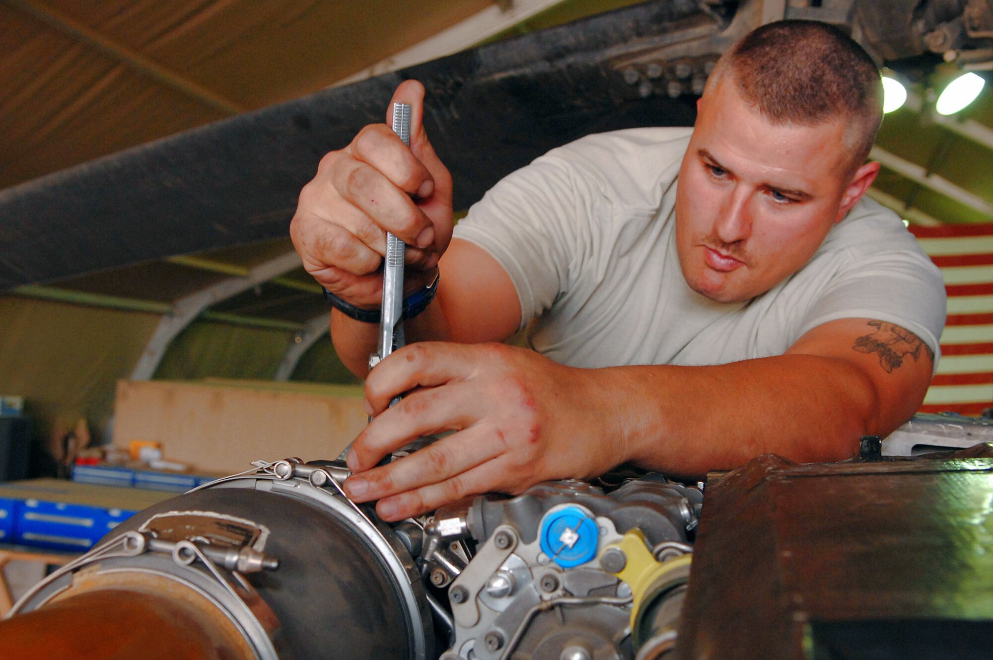 Staff Sgt. Tait Delzer tightens a component on the left-hand engine of an HH-60 Pave Hawk helicopter here March 12.  Sergeant Delzer, a crew chief with the 64th Expeditionary Helicopter Maintenance Unit, performed an inspection on the aircraft after it had been flown 300 hours. During the inspection, all of the panels and covers were removed to facilitate preventative maintenance on the aircraft's systems and equipment. Sergeant Delzer is deployed from Moody Air Force Base, Ga. (U.S. Air Force photo/ Senior Airman Julianne Showalter)