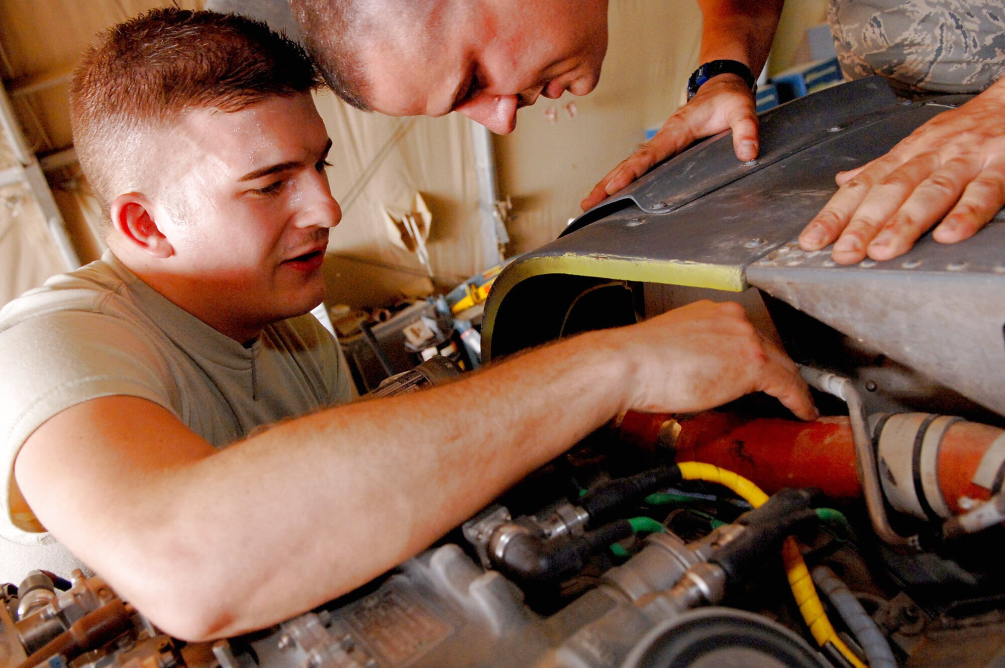 Airman 1st Class Donald Baker (left) and Staff Sgt. Tait Delzer install the left engine air intake on an HH-60 Pave Hawk helicopter March 12 at Balad Air Base, Iraq. Airman Baker and Sergeant Delzer, crew chiefs with the 64th Expeditionary Helicopter Maintenance Unit, performed an inspection on the aircraft after it had been flown 300 hours. As part of the preventative maintenance inspection, they checked all major components to ensure they were in working order. Both Airman Baker and Sergeant Delzer are deployed from Moody Air Force Base, Ga. (U.S. Air Force photo/Senior Airman Julianne Showalter)